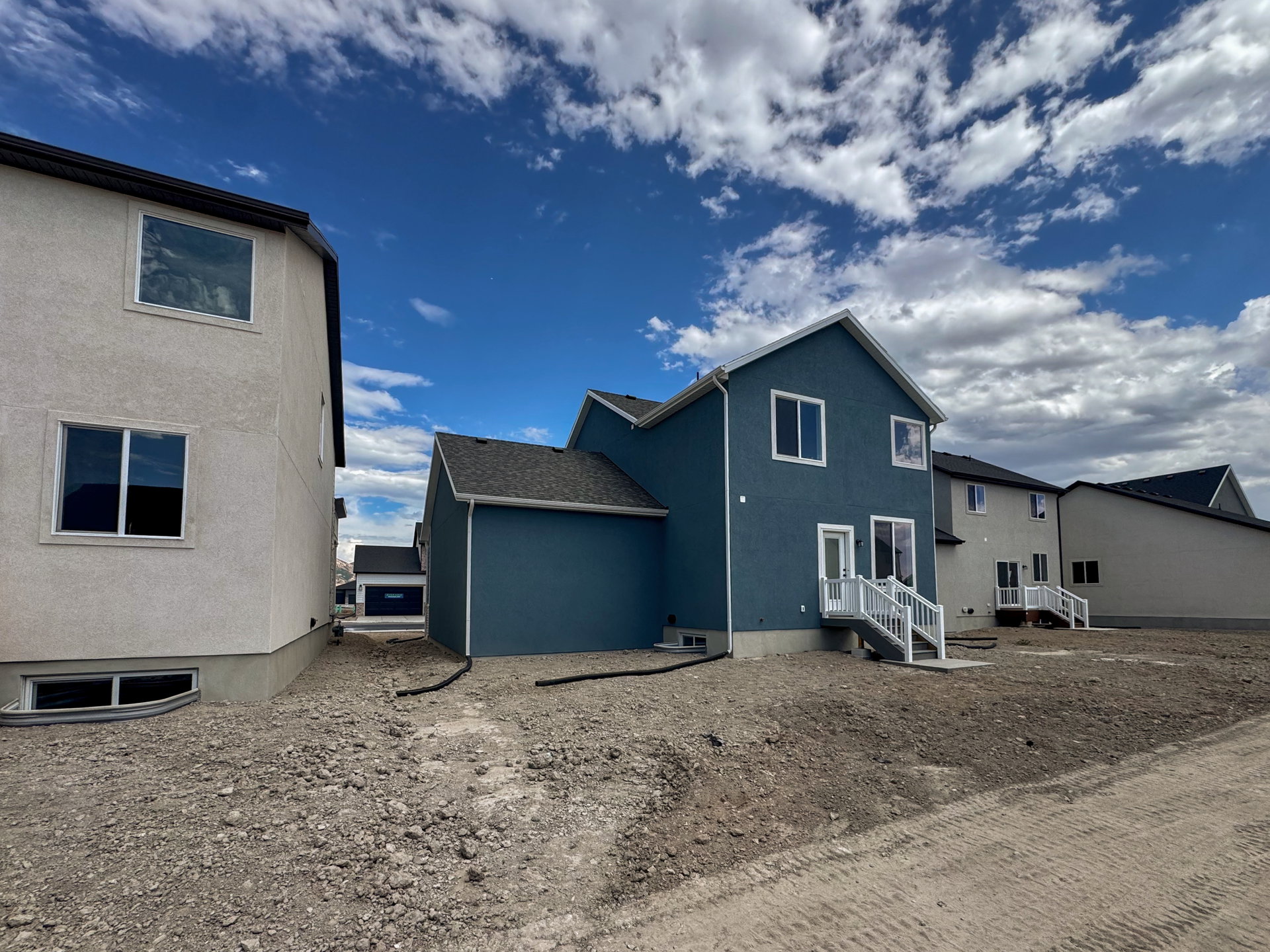 Rear exterior featuring a blue siding finish, white trim windows, white deck with railing, and a walk-out basement
