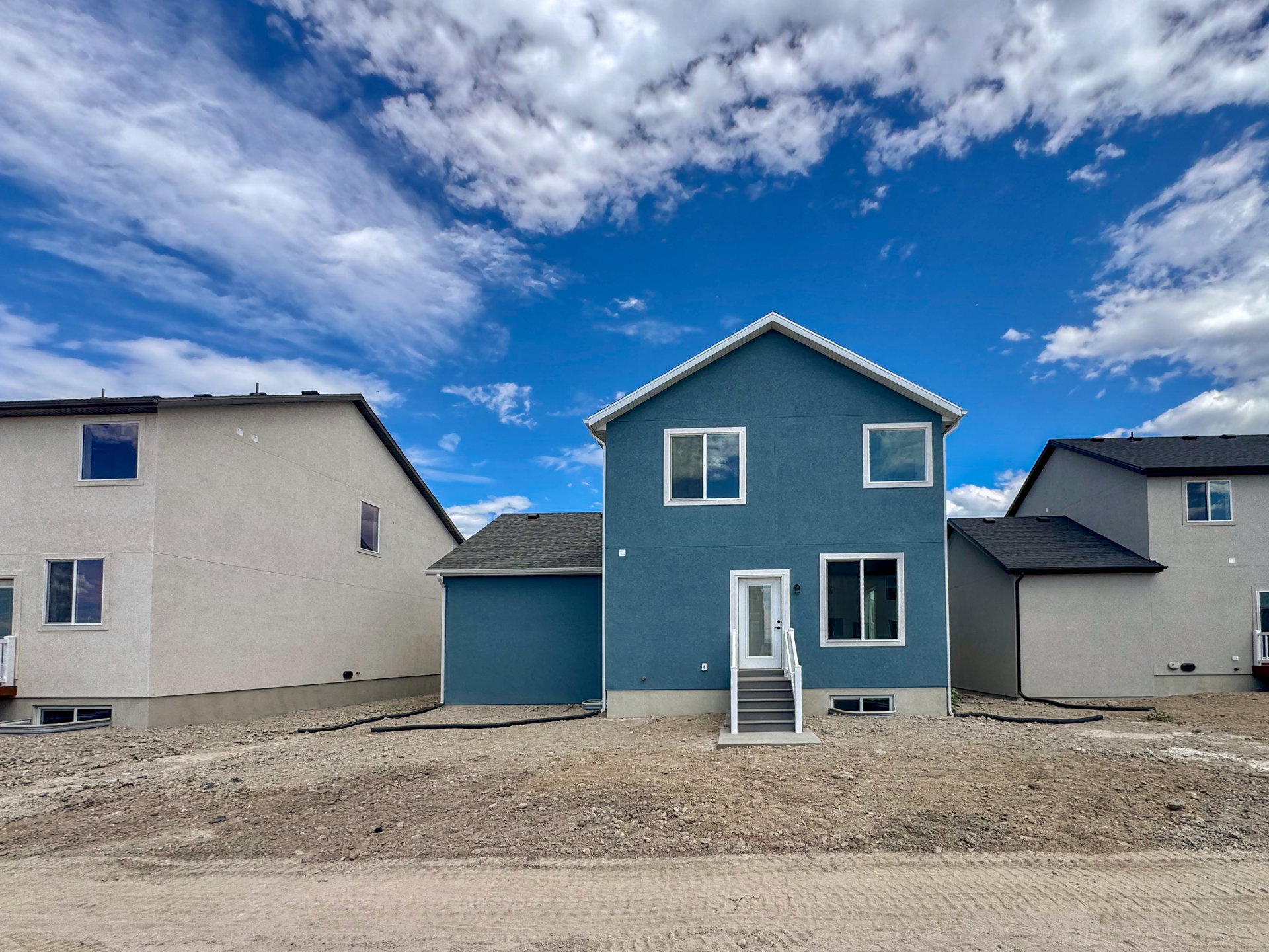 Newly constructed residence featuring a blue stucco exterior