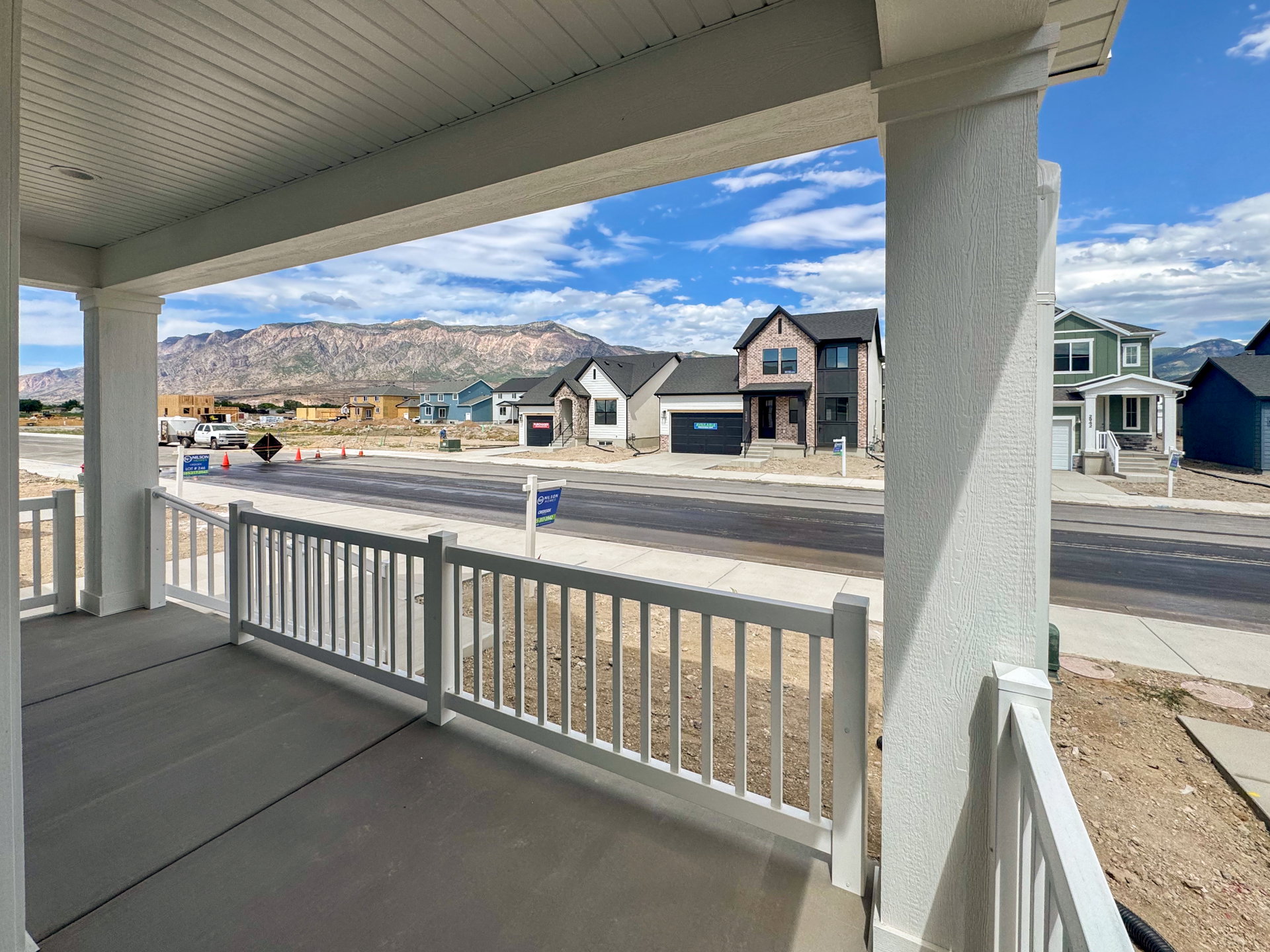 Covered porch featuring a concrete surface and white railing