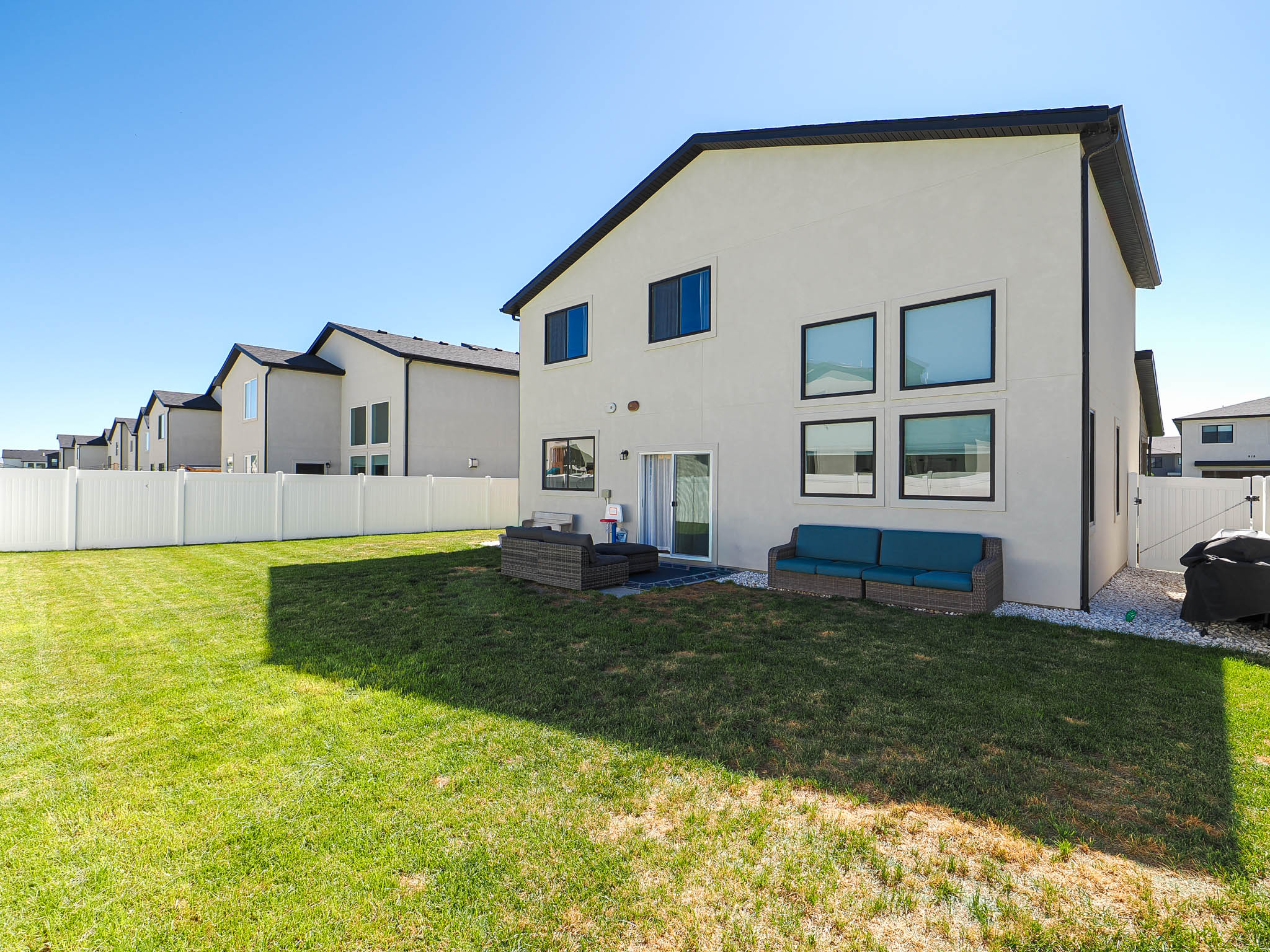 Expansive green lawn with white privacy fencing
