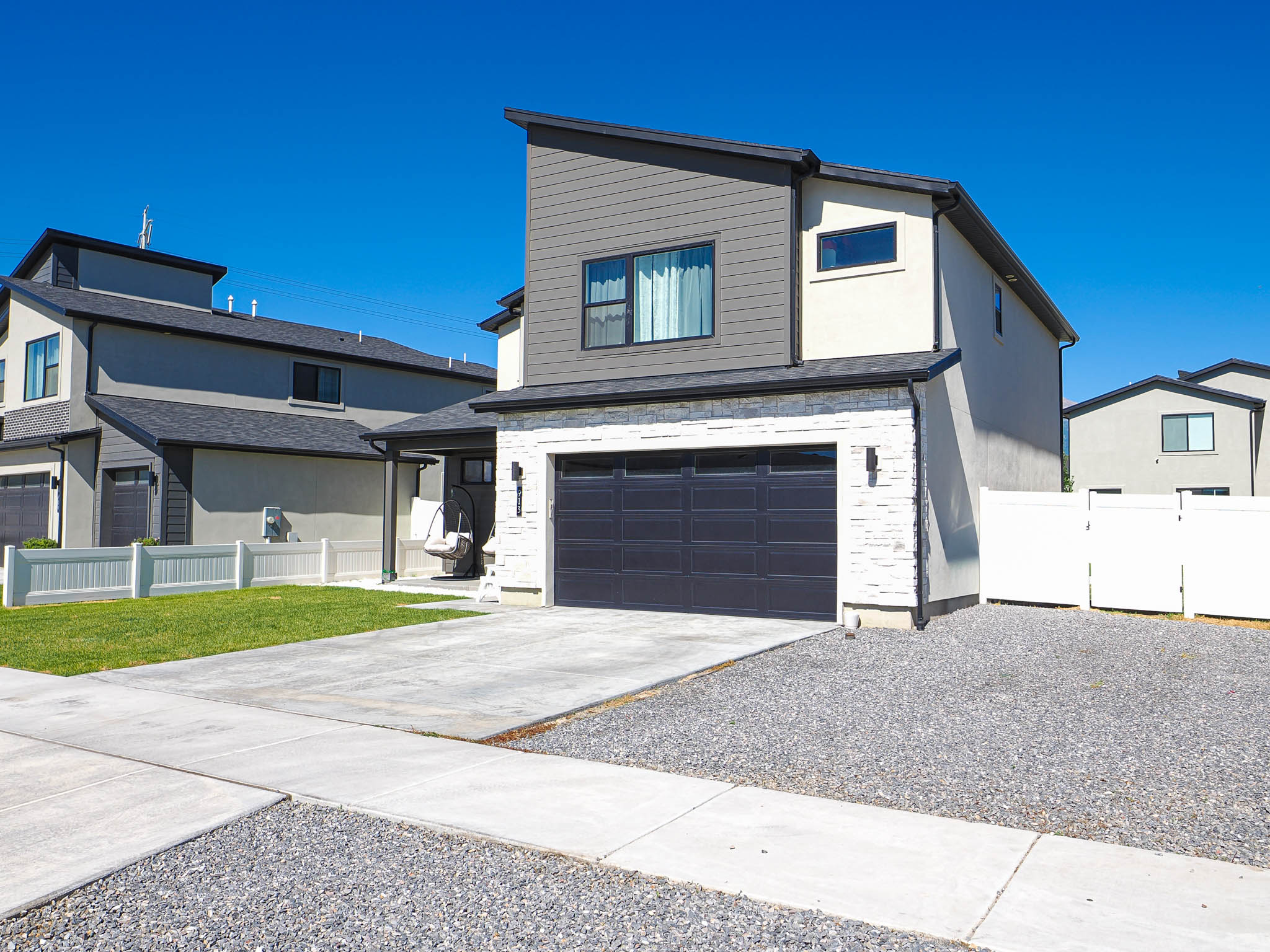 Contemporary exterior with light stucco, dark siding, and a white brick facade