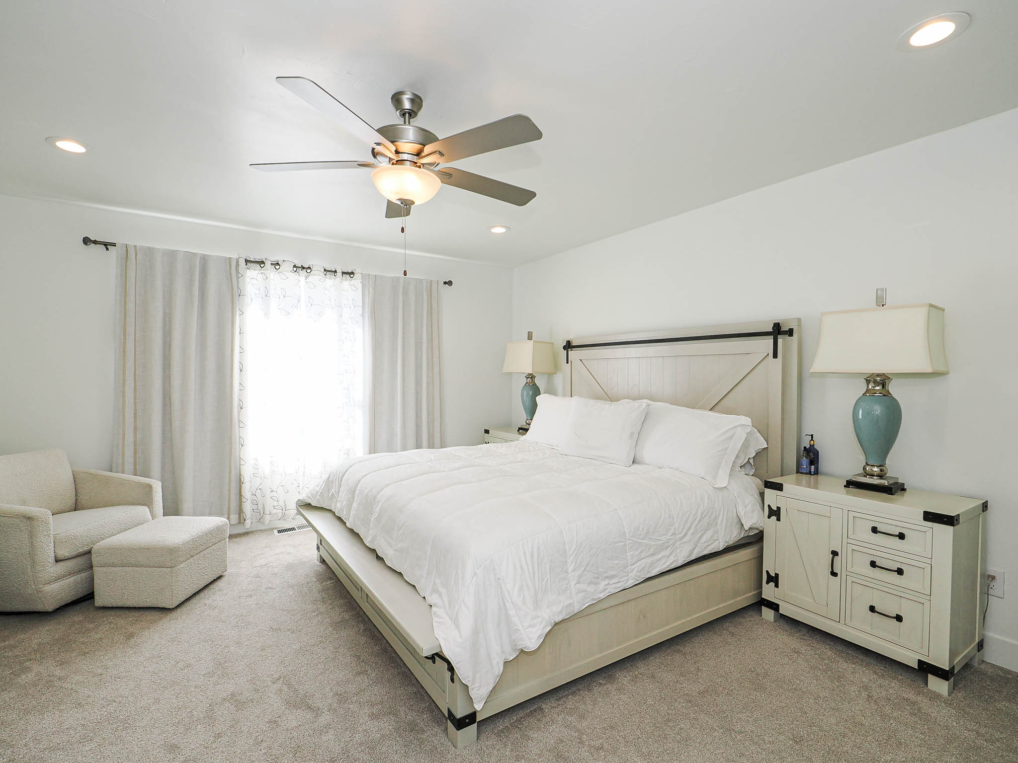 Carpeted bedroom featuring a ceiling fan with integrated lighting, recessed lighting, and a window with curtain rods