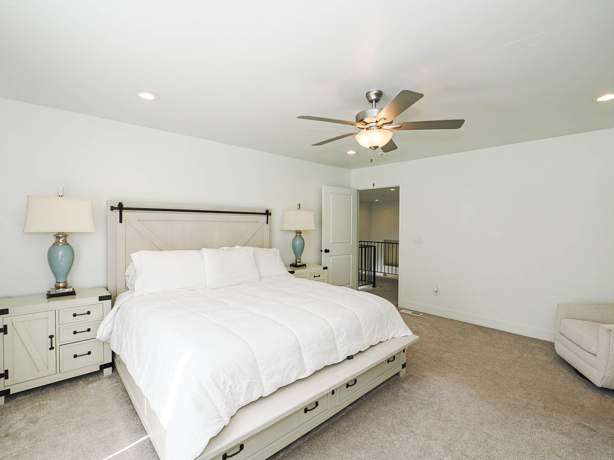 Spacious room featuring neutral carpeting, recessed lighting, and a ceiling fan with light fixture
