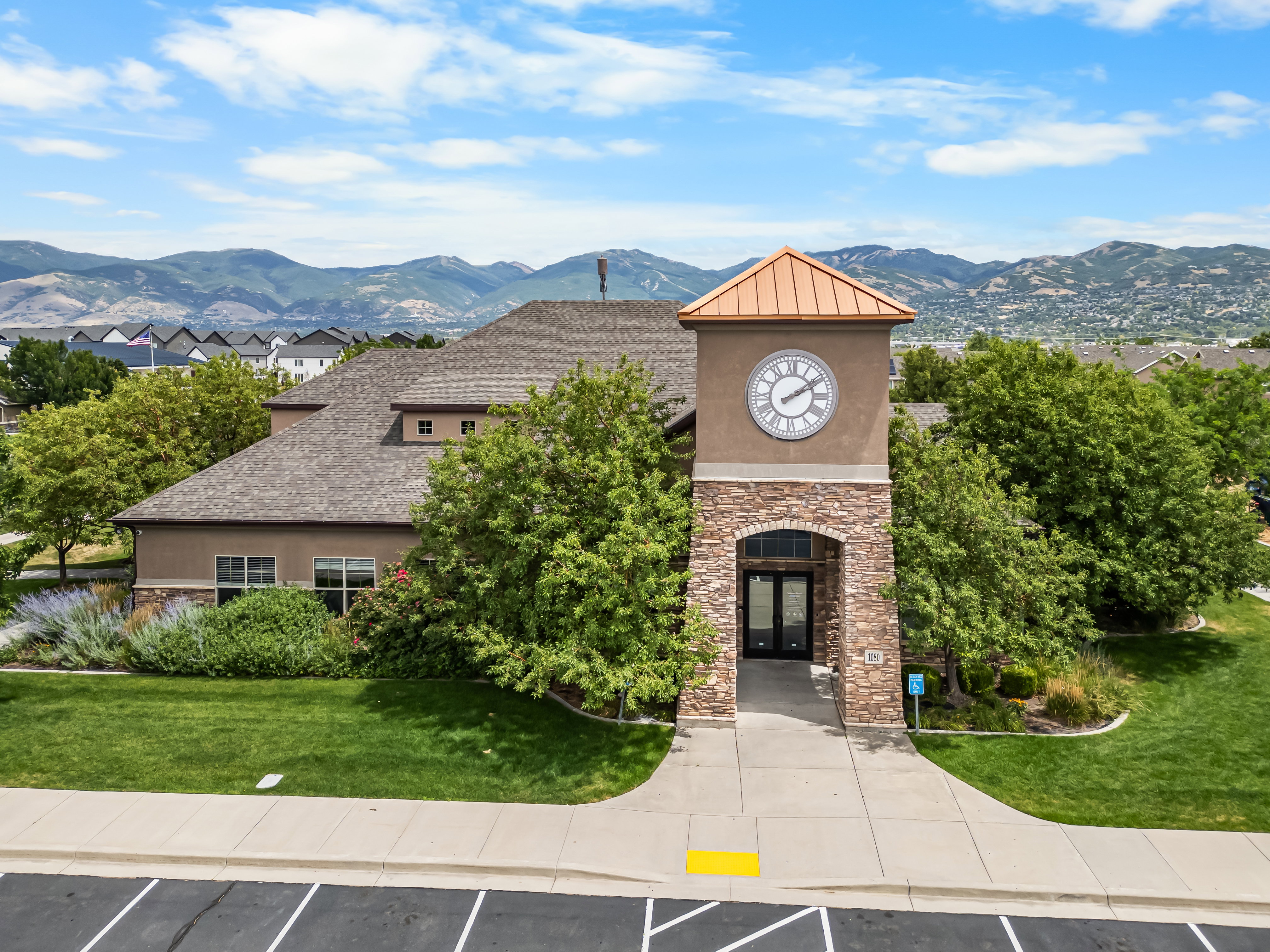 Clock tower entrance featuring stone accents and a copper-finish roof