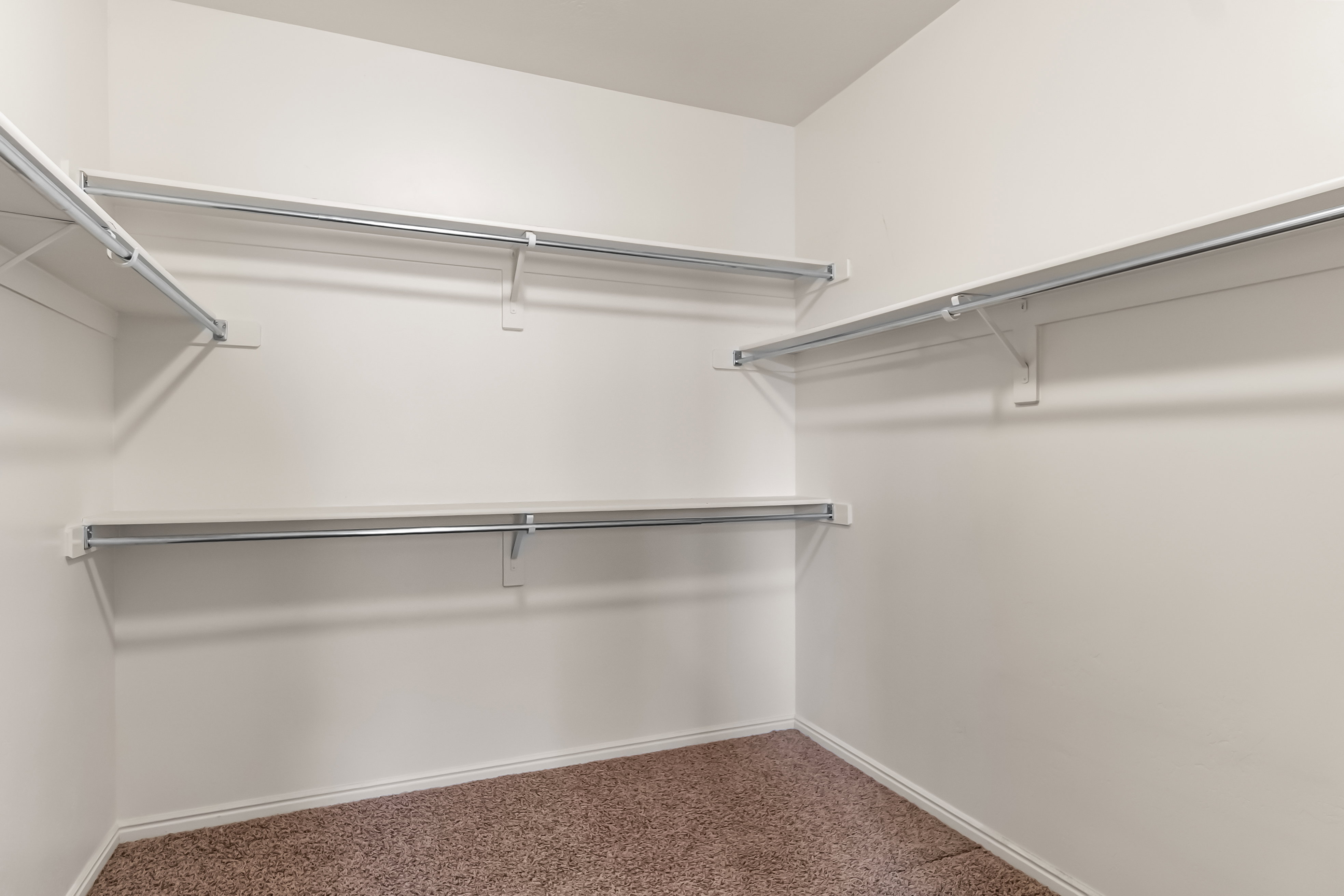 Walk-in closet featuring extensive wire shelving and hanging rods