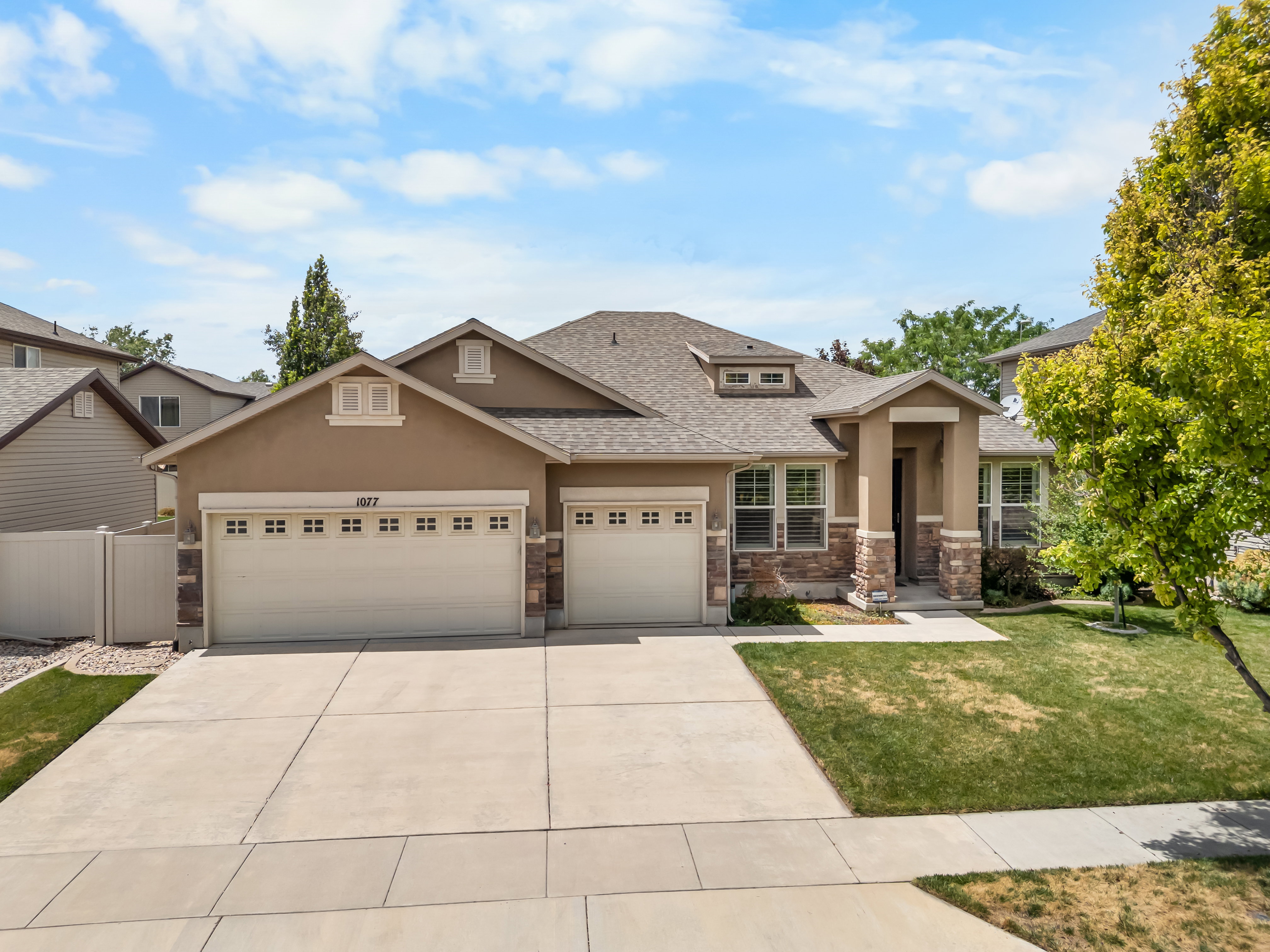 Contemporary stucco exterior featuring a stone facade and a prominent front entry