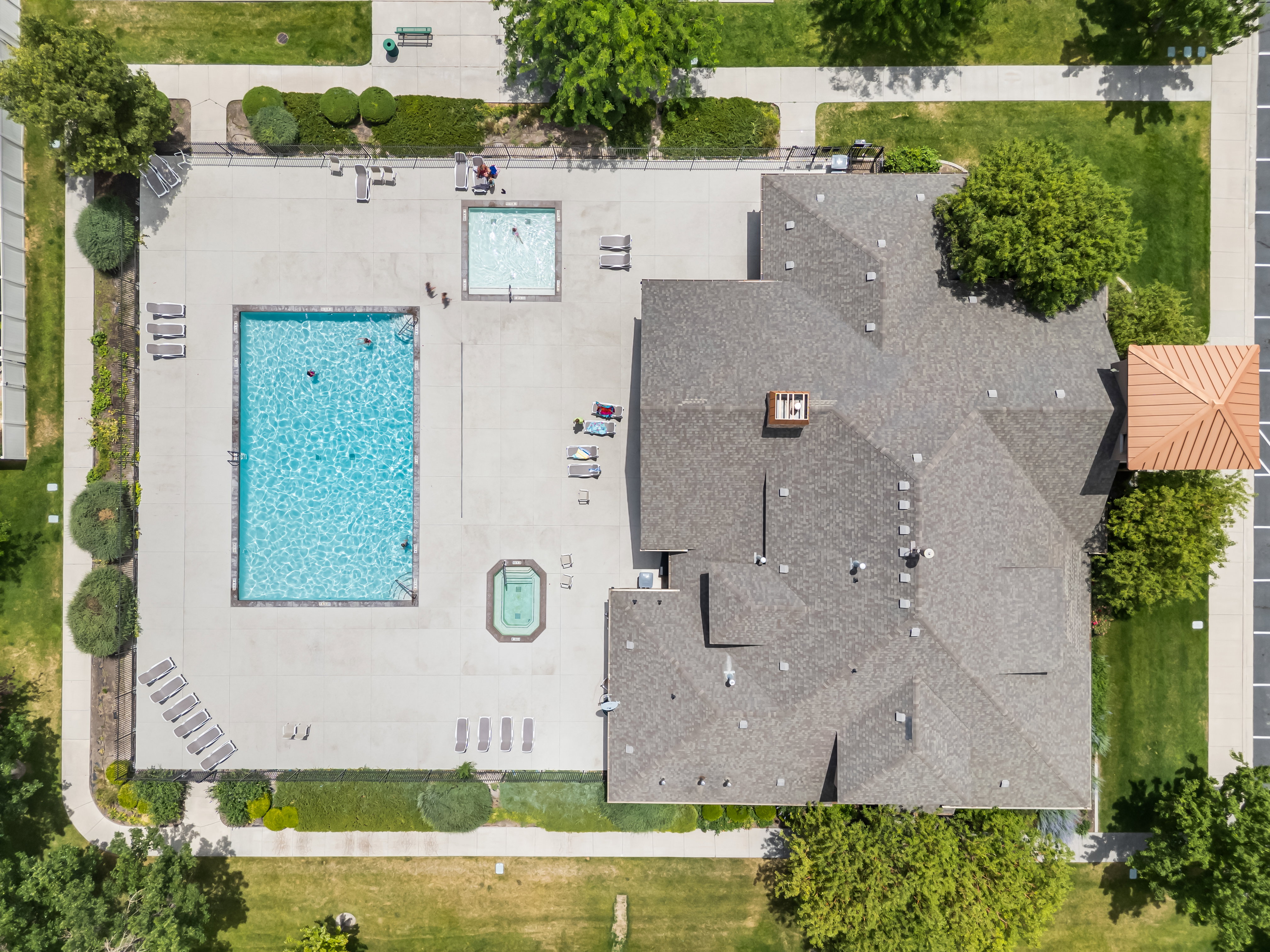 Outdoor recreation area featuring a rectangular swimming pool, a second smaller square pool, and a spa