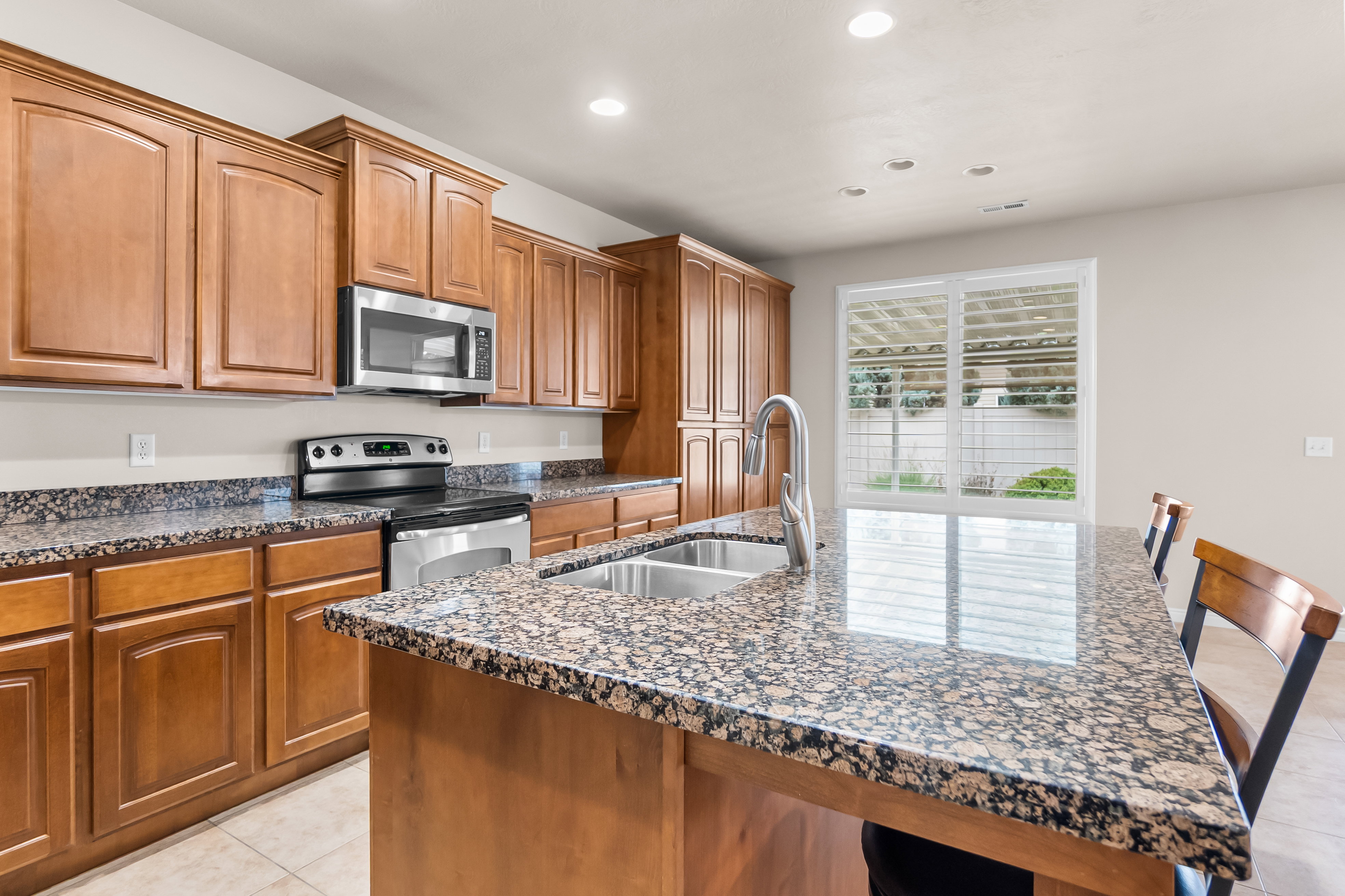 Spacious kitchen featuring an expansive island with a double basin sink and a gooseneck faucet