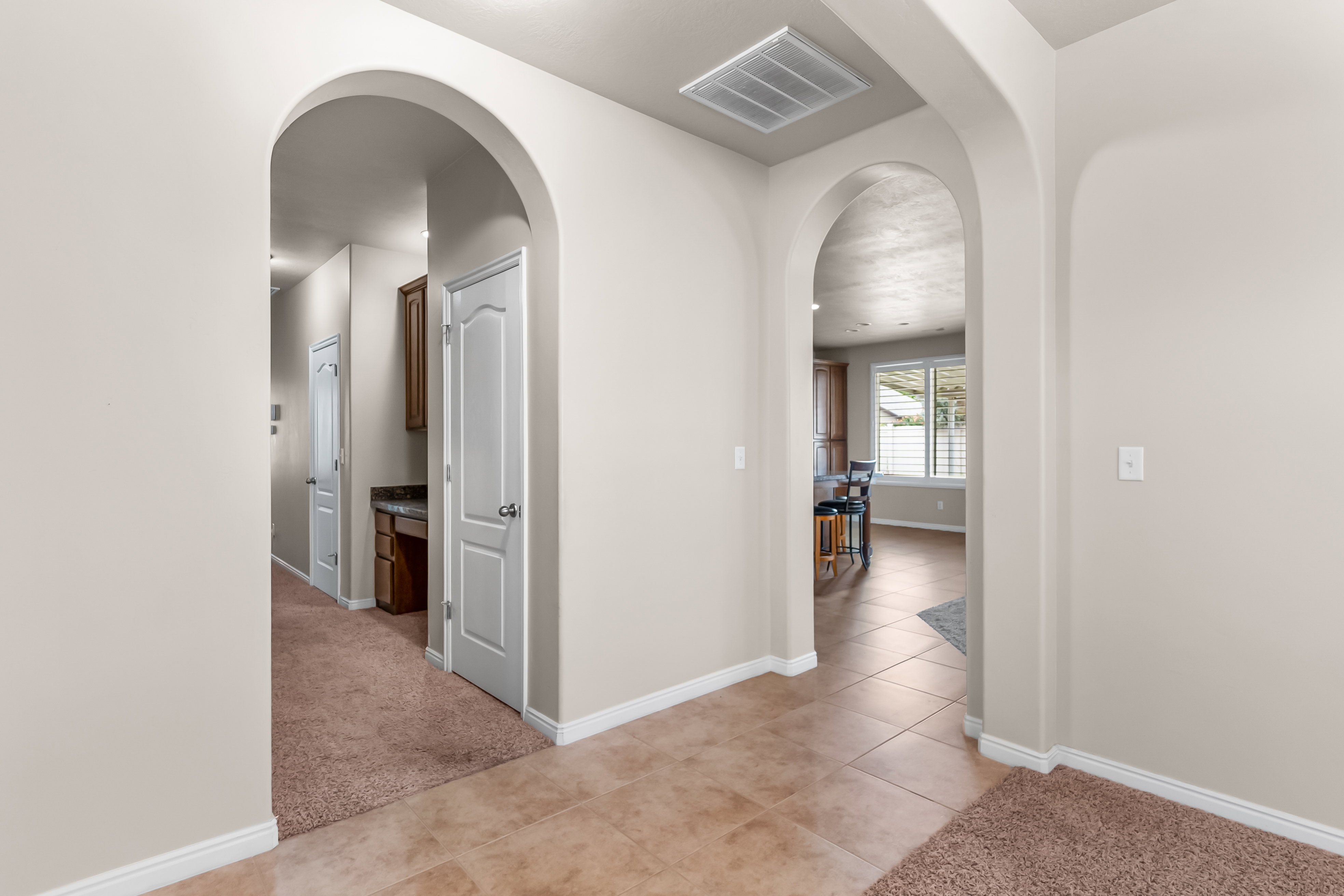 Arched doorways defining hallways with recessed lighting