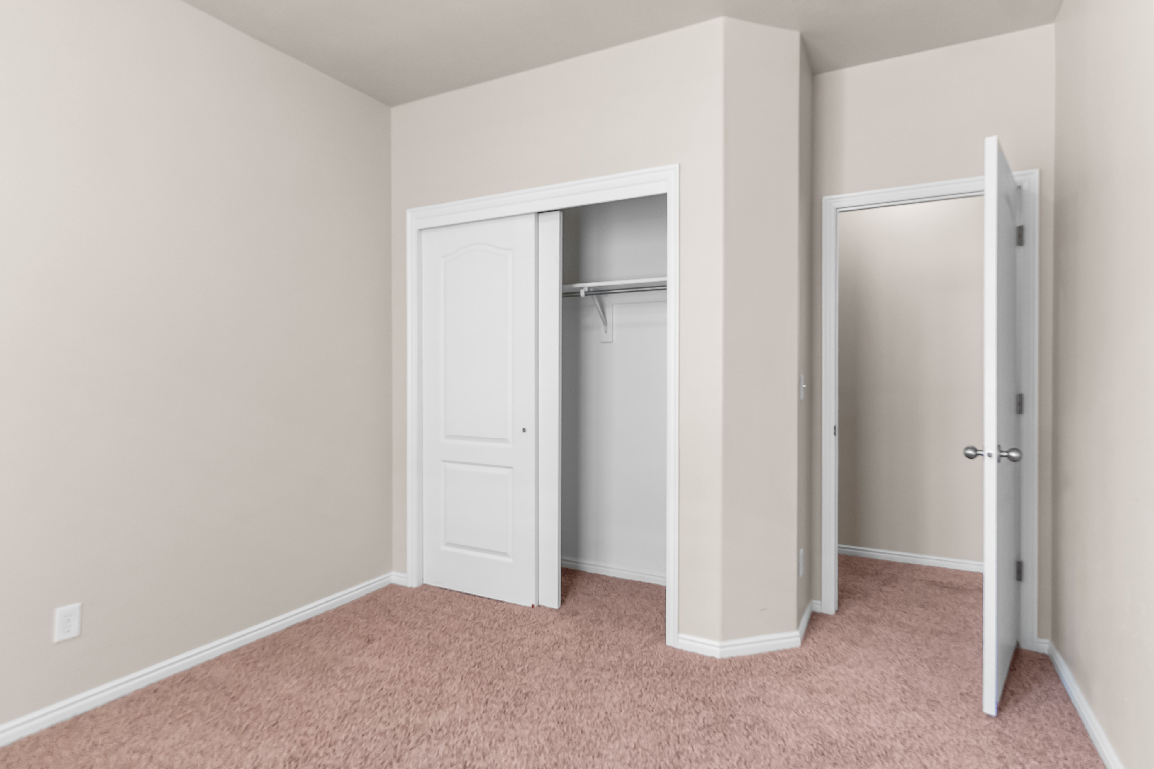Neutral-toned walls complement plush carpeting