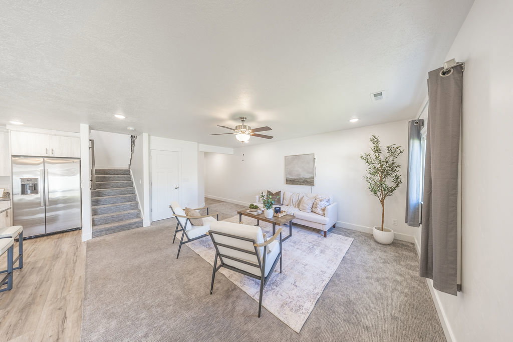 Spacious living area featuring light-toned carpeting and recessed lighting