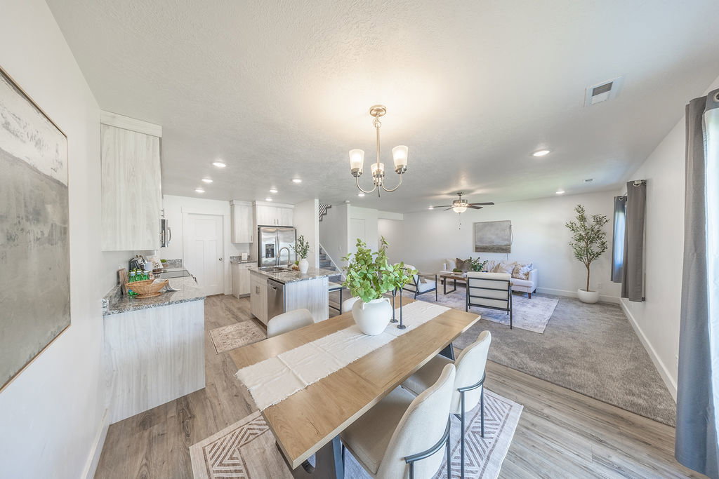 Open-concept living area with a dining space, kitchen, and living room.  Lots of lighting.  Lots of NATURAL LIGHT.