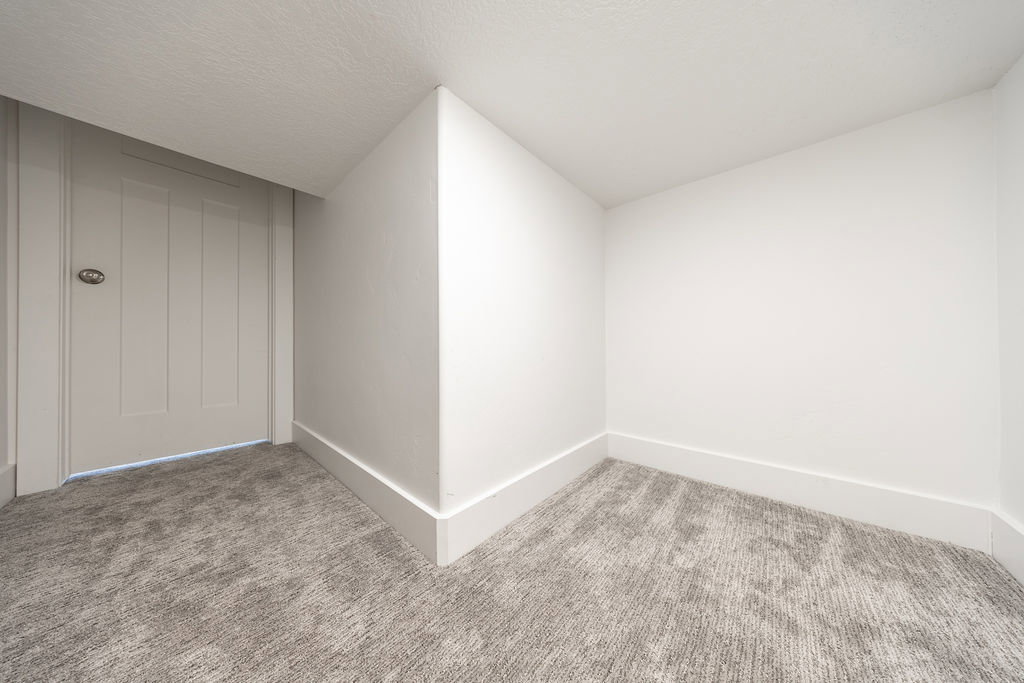 Neutral-toned wall-to-wall carpeting and crisp white walls