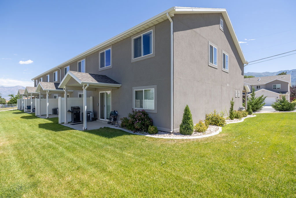 Townhome exterior with stucco siding and white trim.  Green space around this END UNIT.