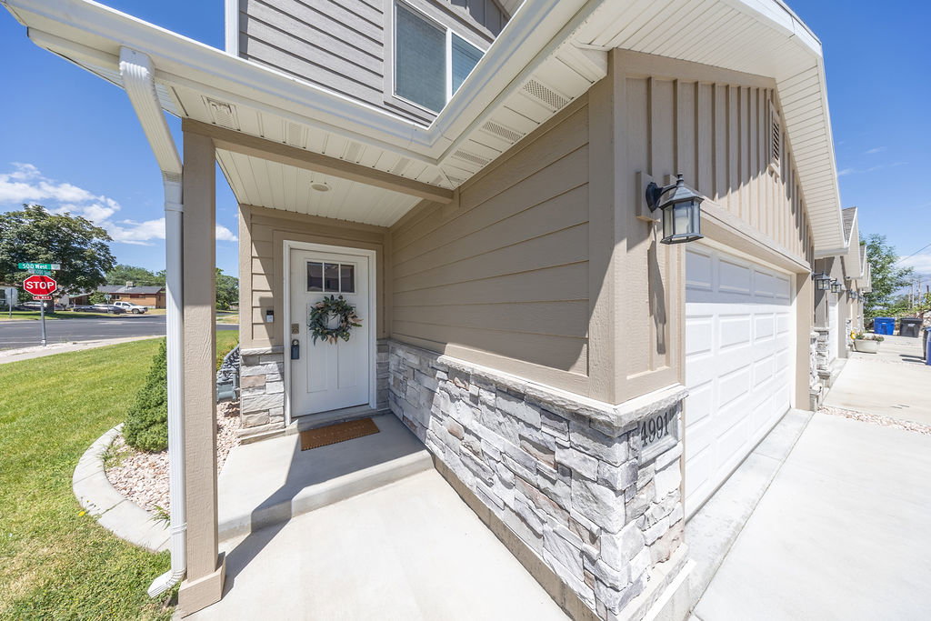 Exterior features include horizontal siding, vertical board, and stone veneer detailing.