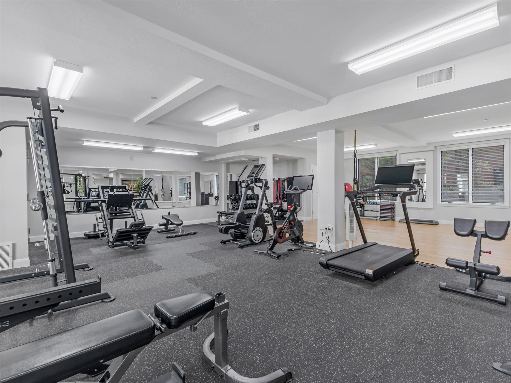 Fitness room featuring a rubberized flooring system and mirrored walls