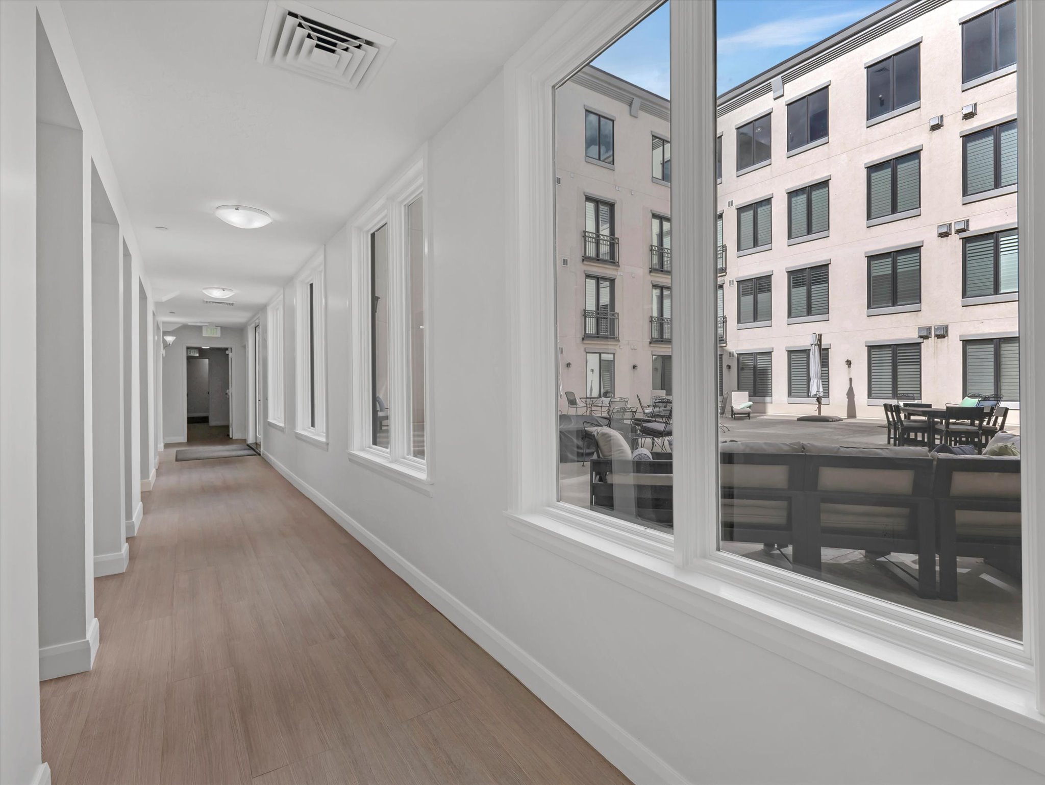 Hallway featuring wood-finish flooring, recessed lighting, and white trim