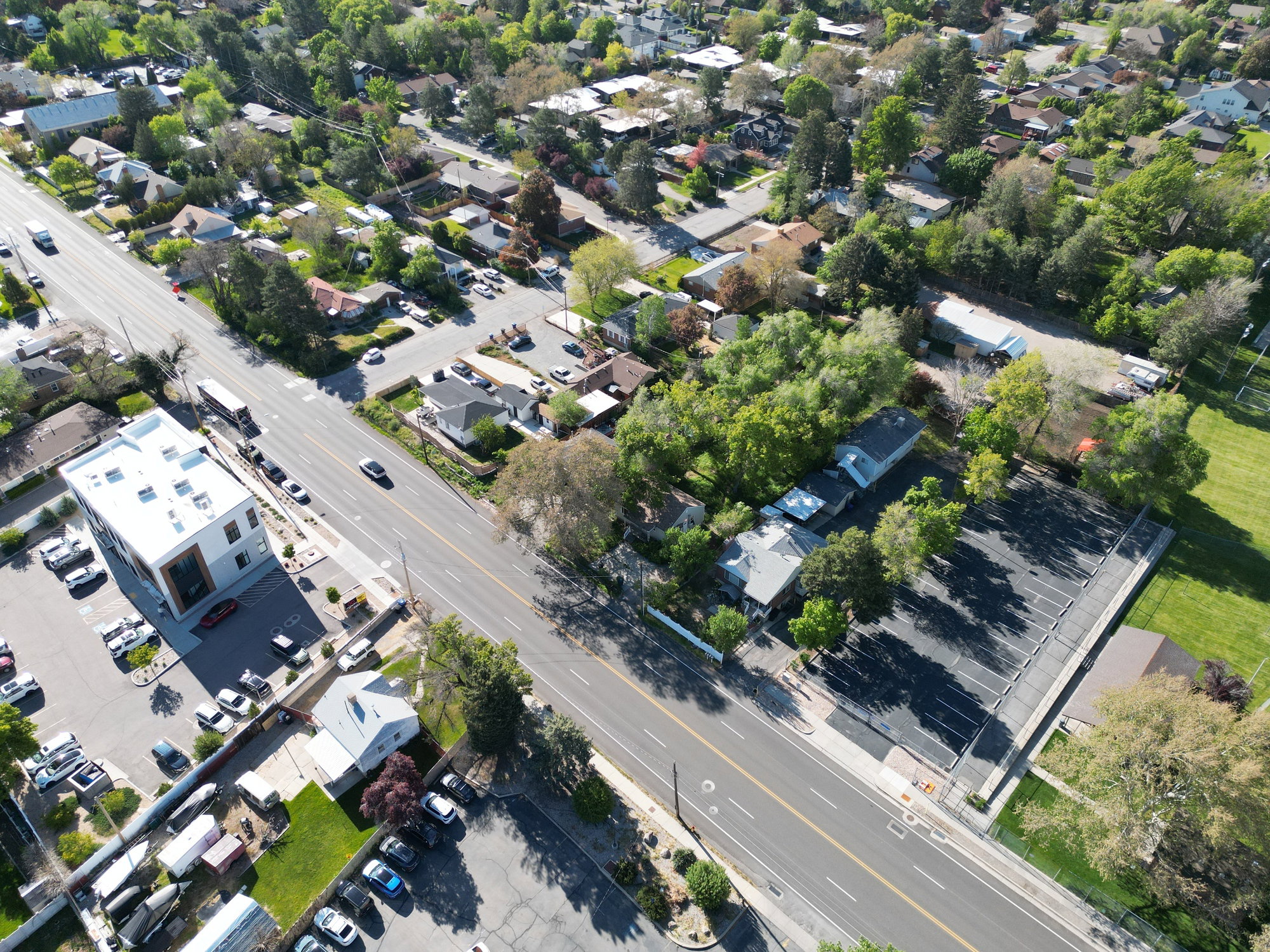 Aerial perspective showcasing a mixed-use commercial and residential district with abundant mature trees