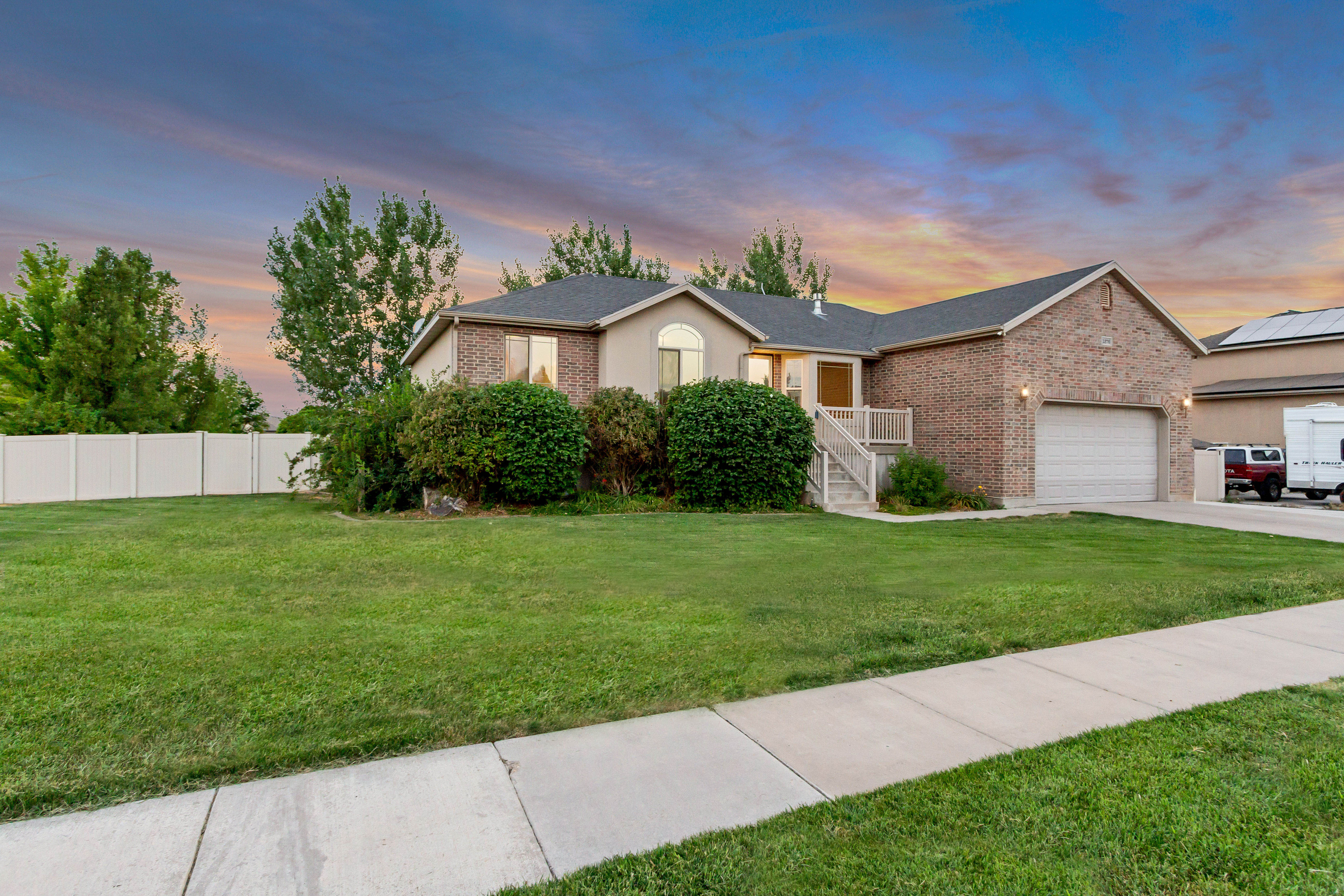 Traditional-style residence featuring a brick and stucco exterior, an attached two-car garage, and a concrete driveway