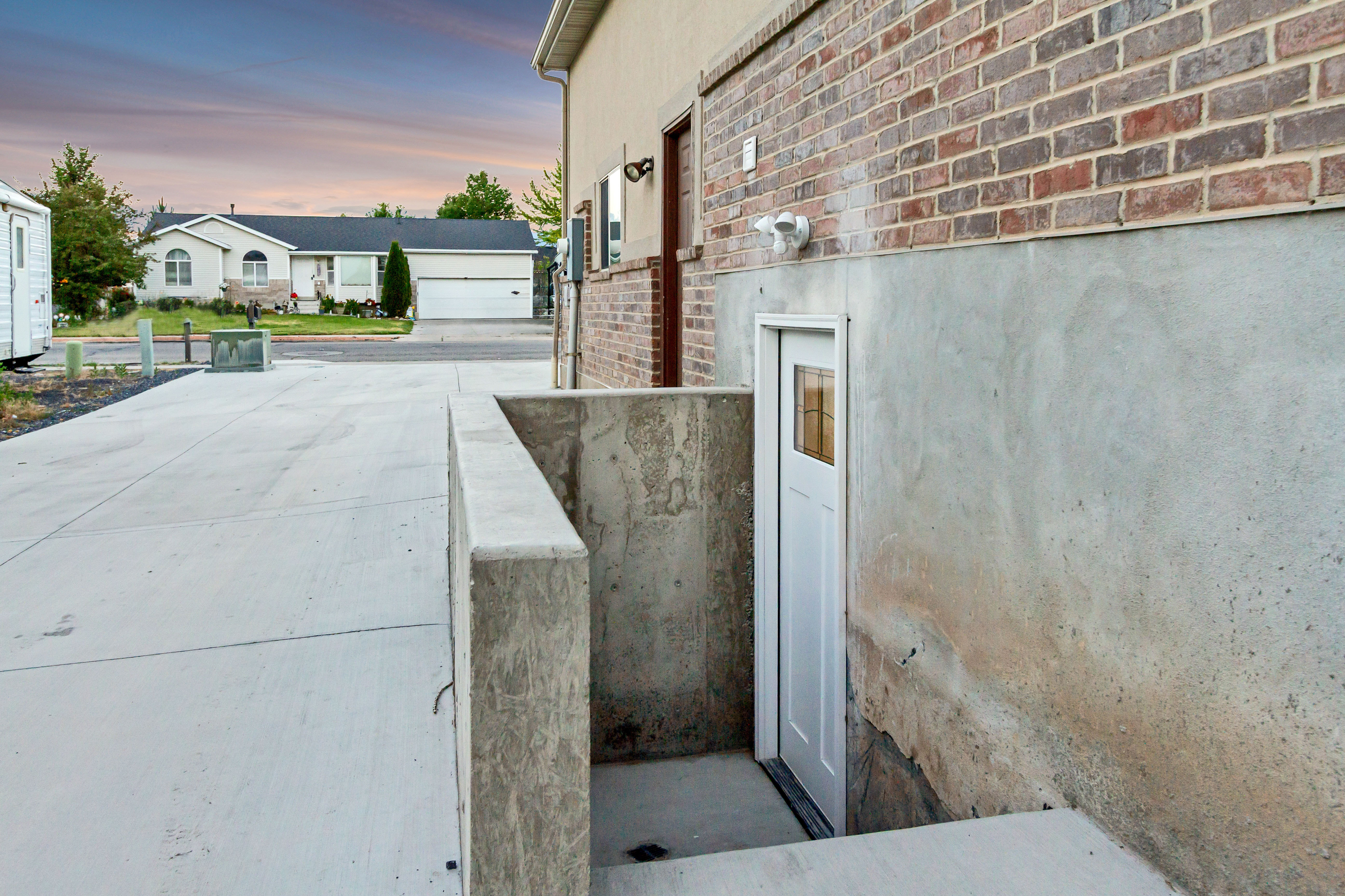 Concrete pathway leading to a white exterior door with a window panel