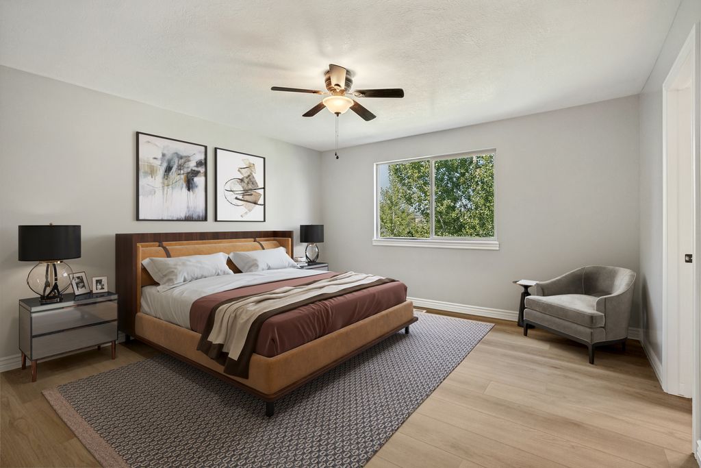 Expansive room featuring light wood-finish flooring, a large window, and a ceiling fan with integrated lighting