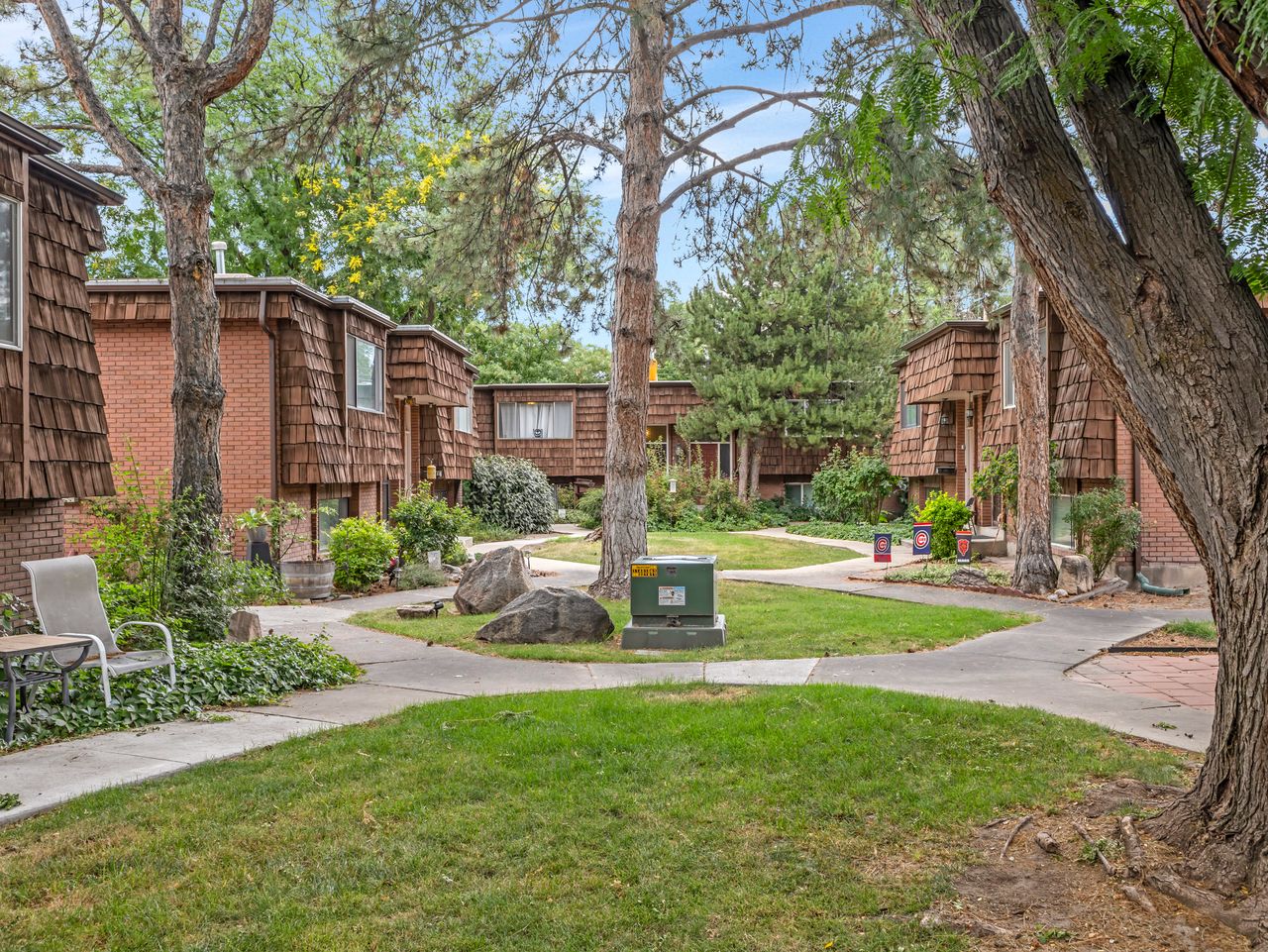 Central courtyard featuring a manicured lawn, established trees, and concrete pathways