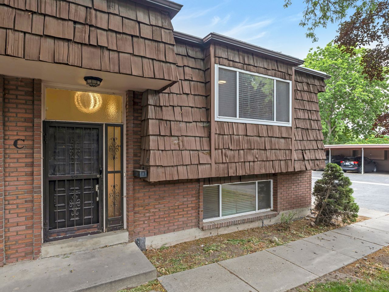 Exterior facade featuring brown shingle siding and brick detailing