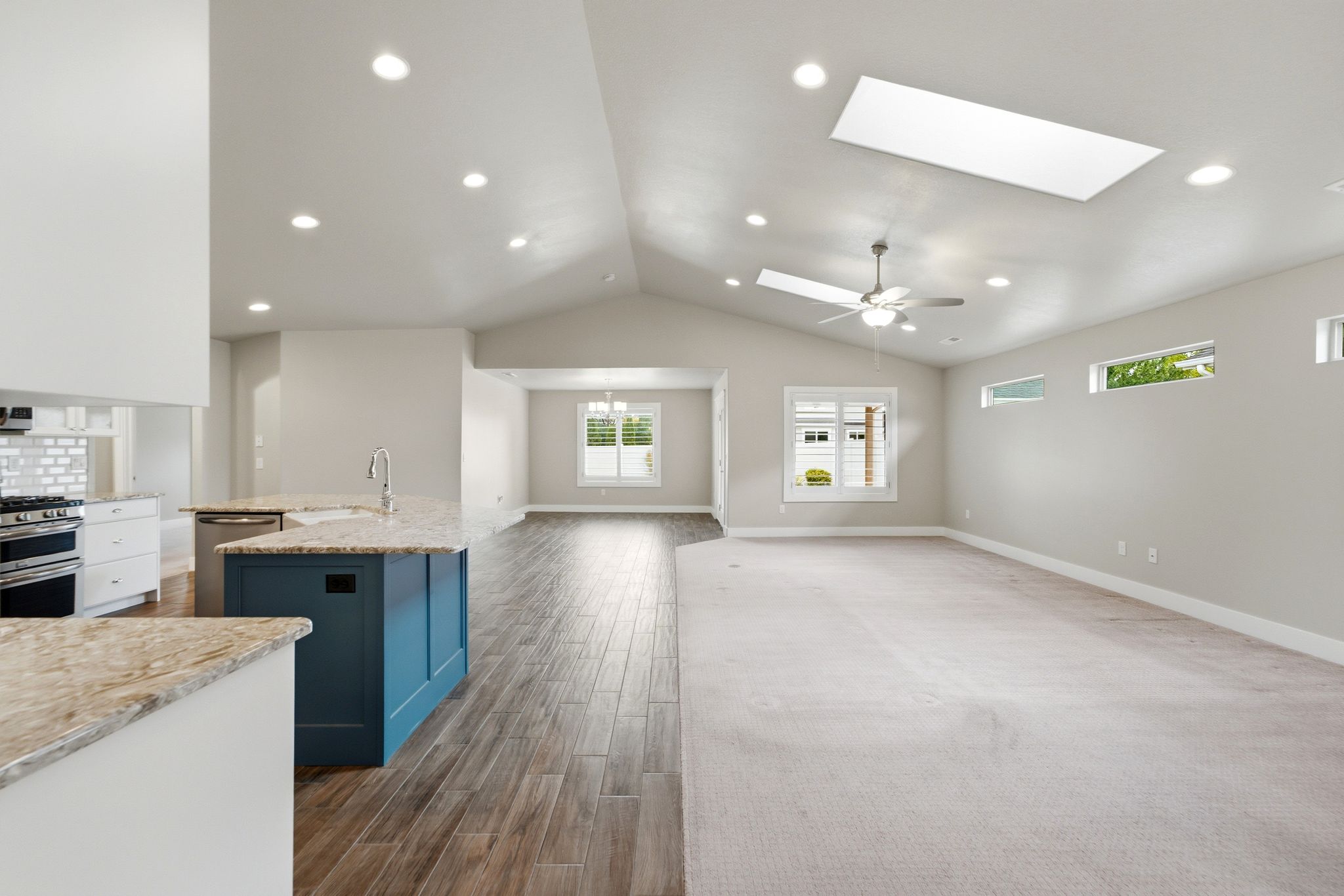 Open-concept living space featuring vaulted ceilings, recessed lighting, and a skylight
