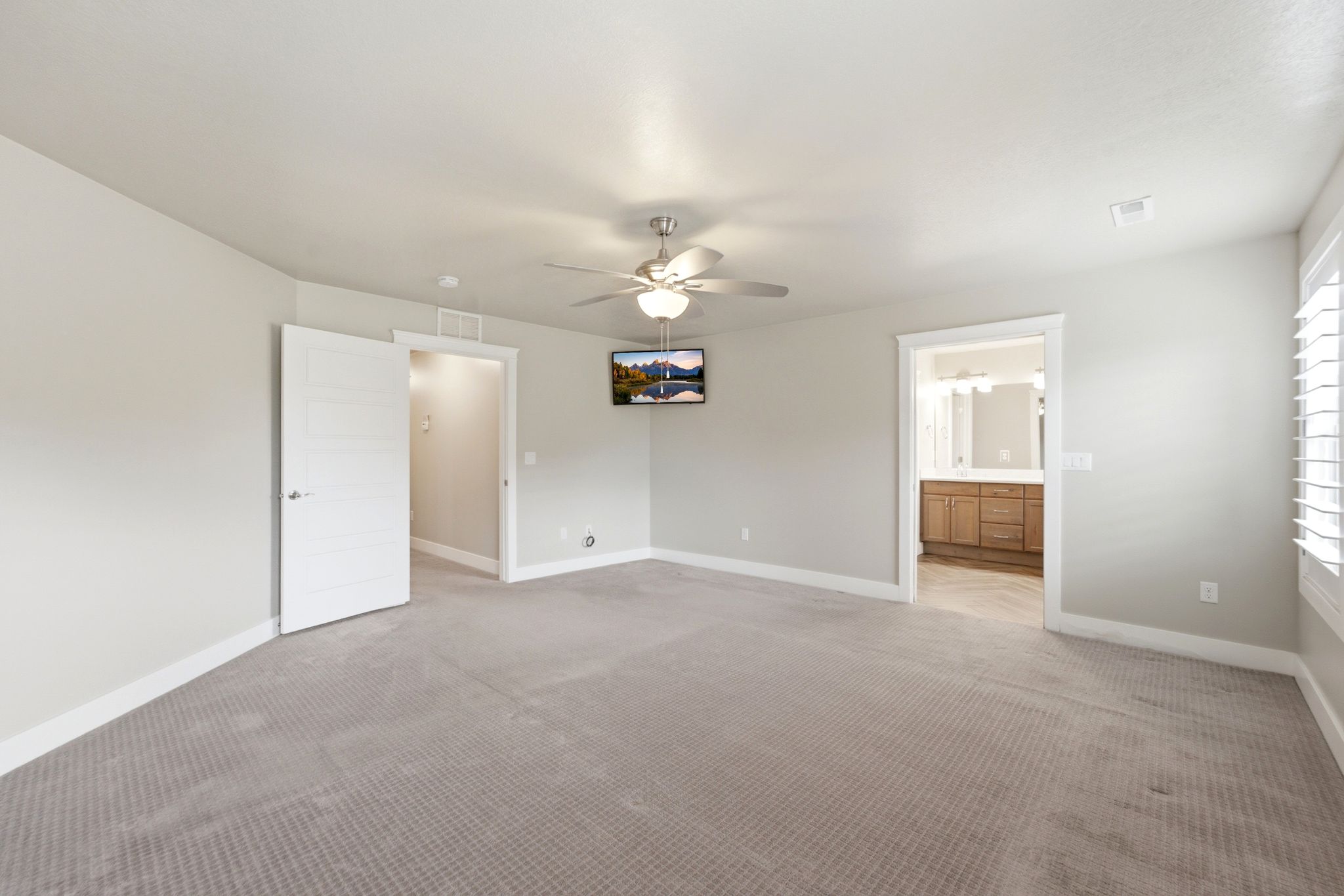 Spacious room featuring neutral carpeting and light gray walls