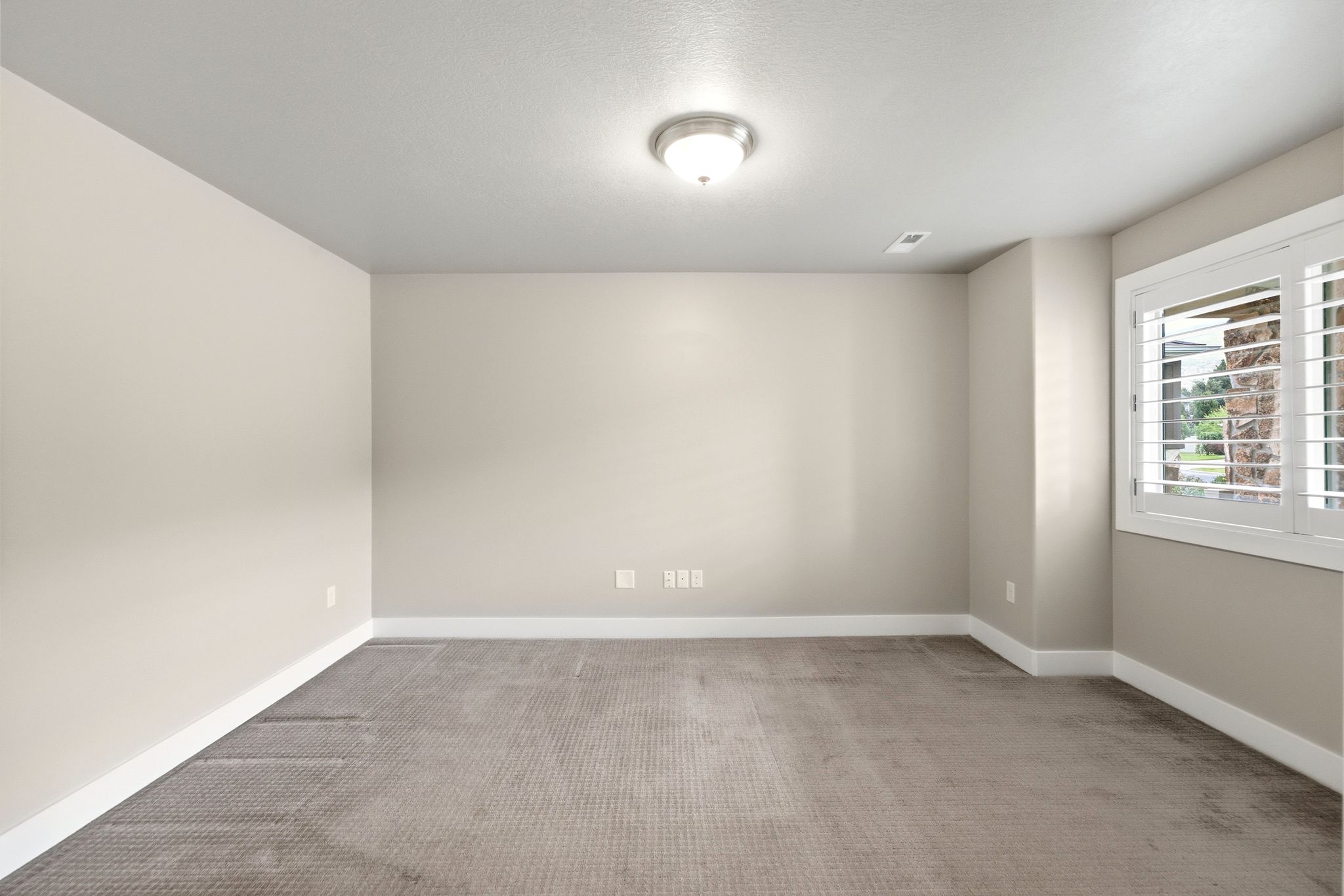 Room featuring neutral wall tones, textured carpeting, and white baseboards