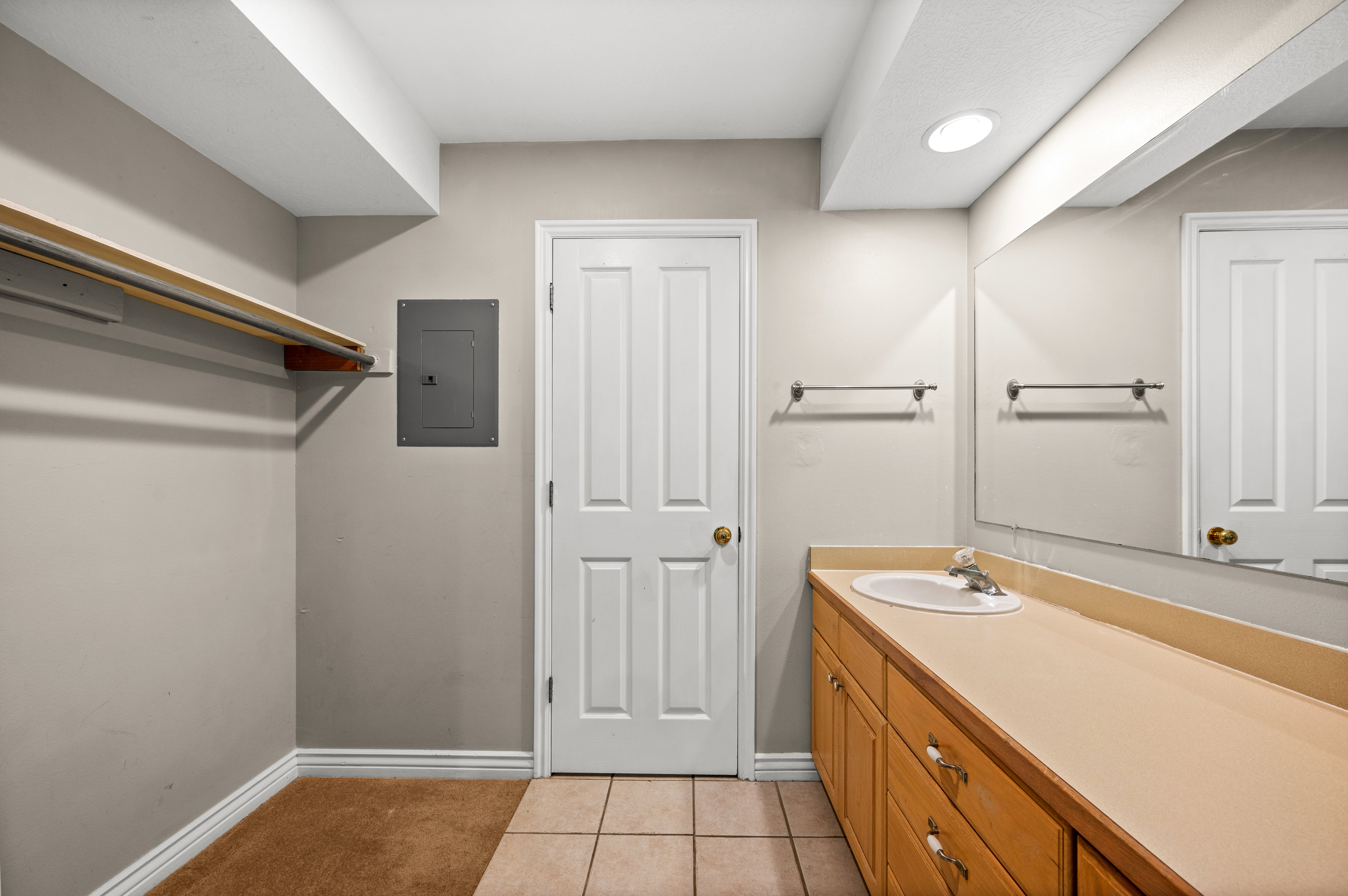 Bathroom vanity with an integrated sink, extended countertop, and wood-finish cabinetry