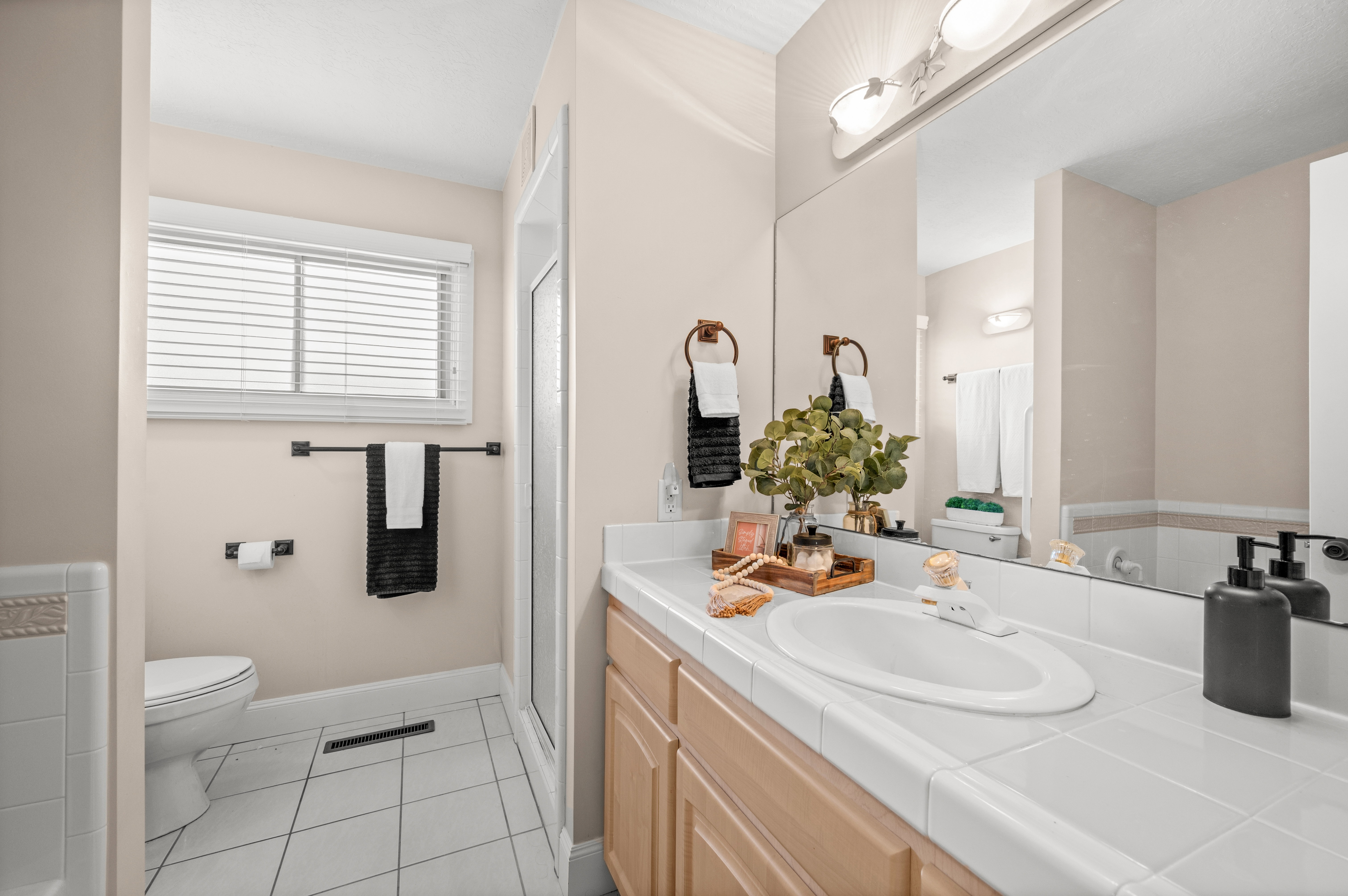 Escape to your own private retreat in this spacious bathroom, where a separate soaking tub and walk-in shower create the perfect balance of comfort, relaxation, and everyday luxury.