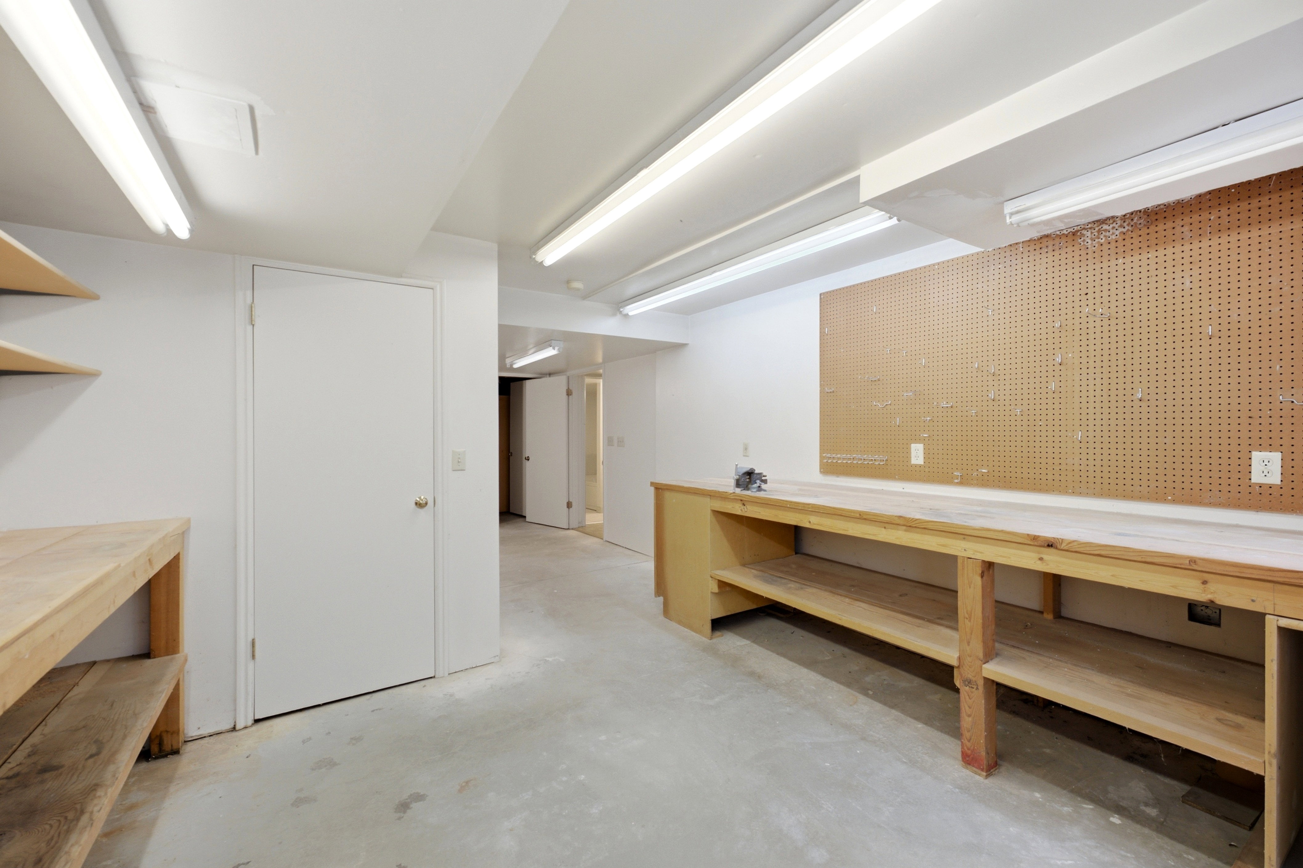Utility room featuring concrete flooring and fluorescent lighting