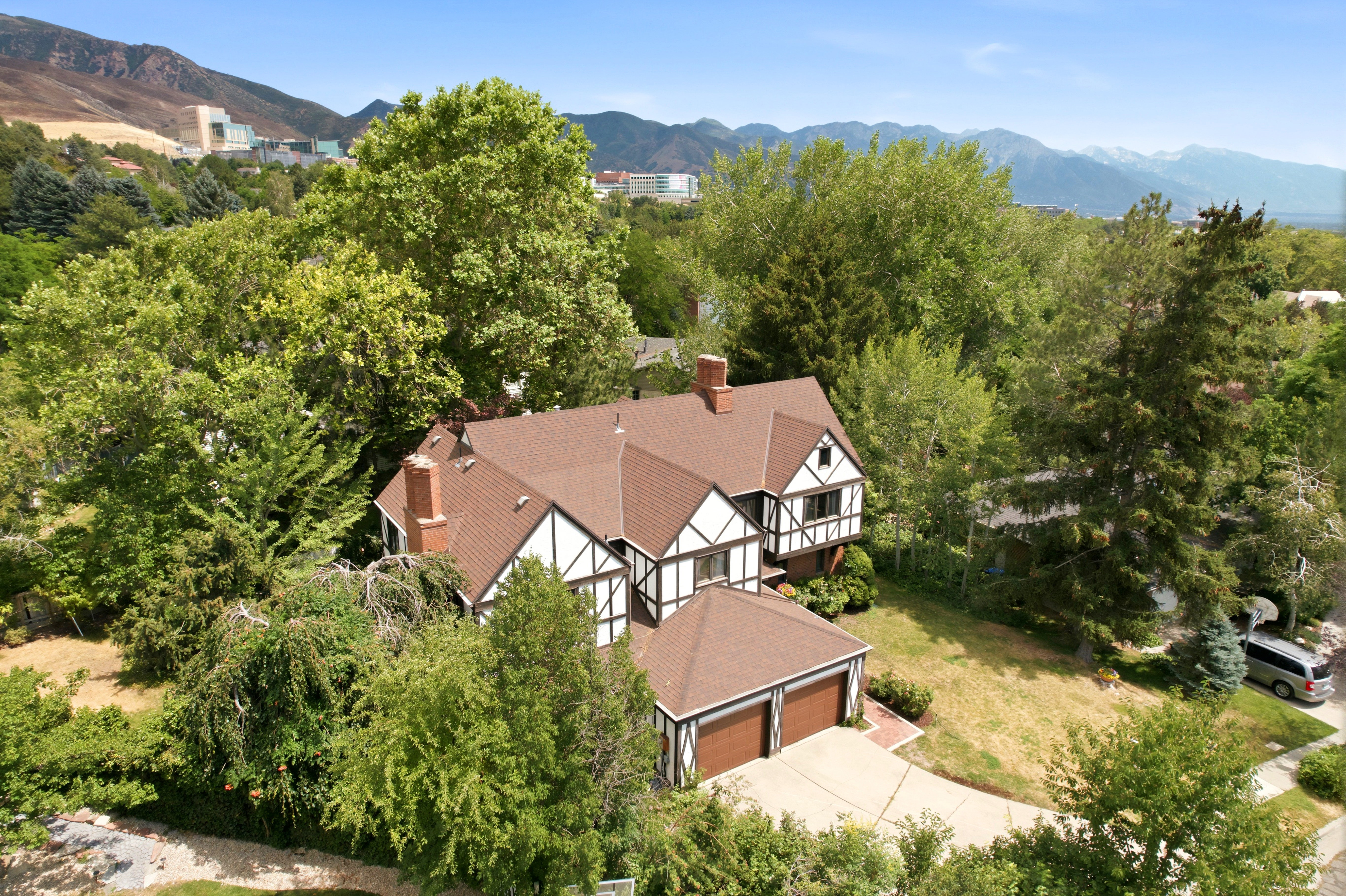 Tudor-style residence featuring brown shingles, white stucco, and dark timbering