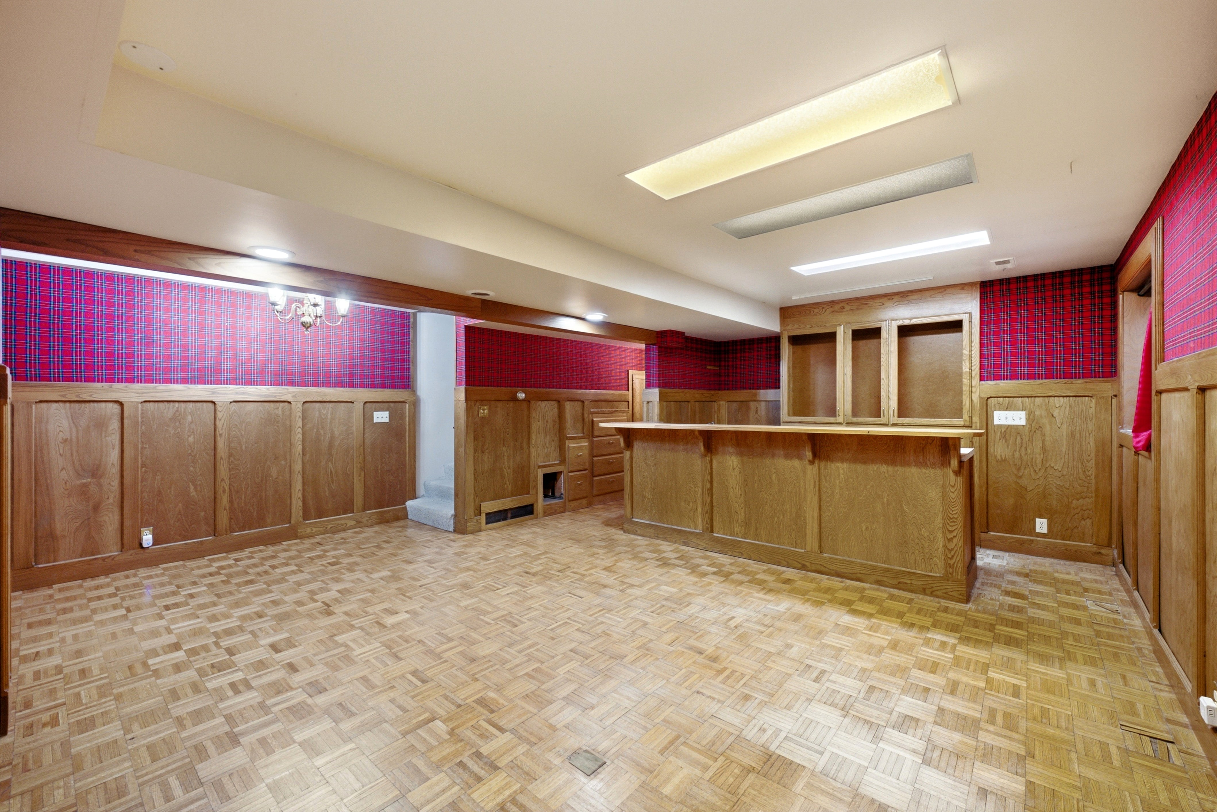 Finished room featuring a built-in bar with open shelving, wood-finish flooring, and recessed ceiling lighting
