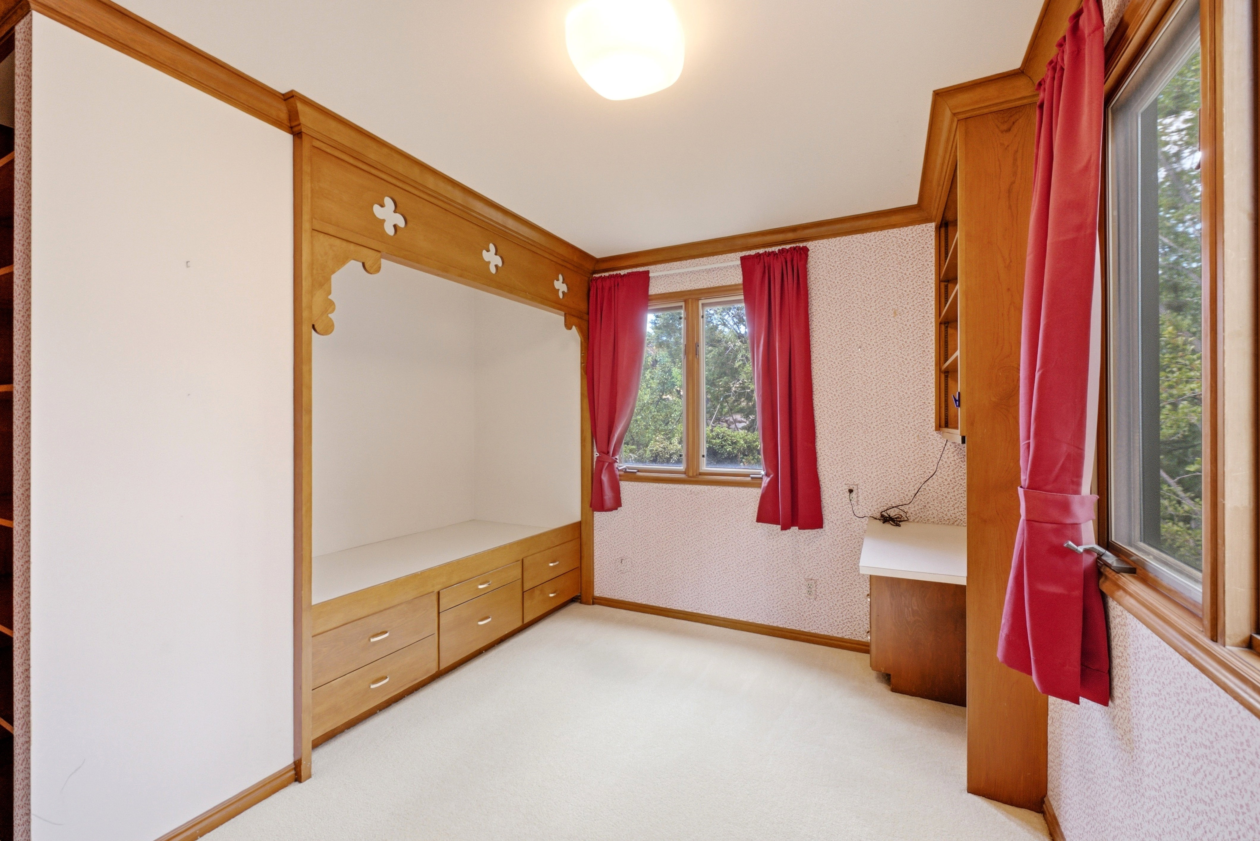 Built-in wooden bed frame with integrated drawers and decorative trim