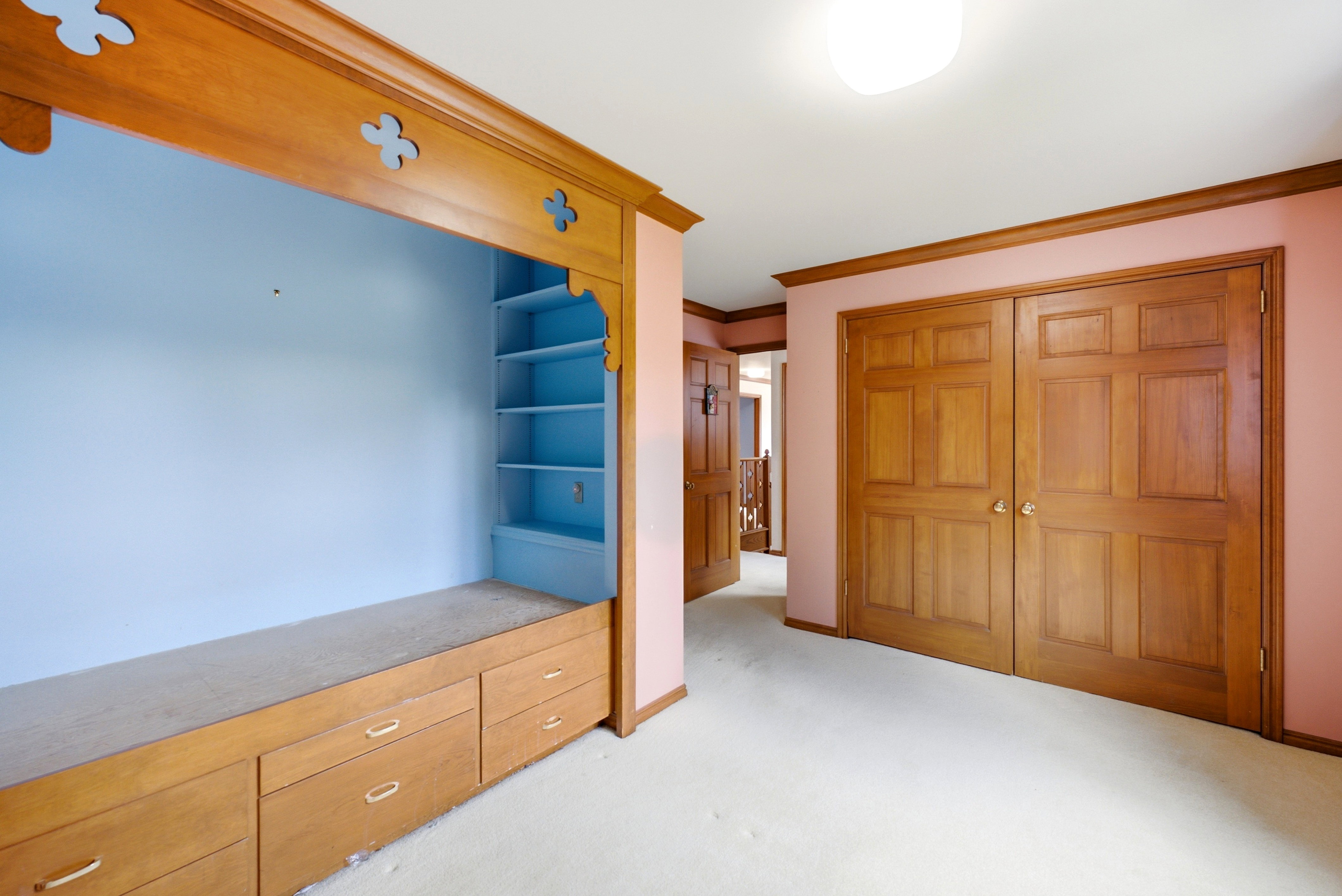 Built-in wood cabinetry with decorative trim and integrated shelving, featuring a long countertop and multiple drawers
