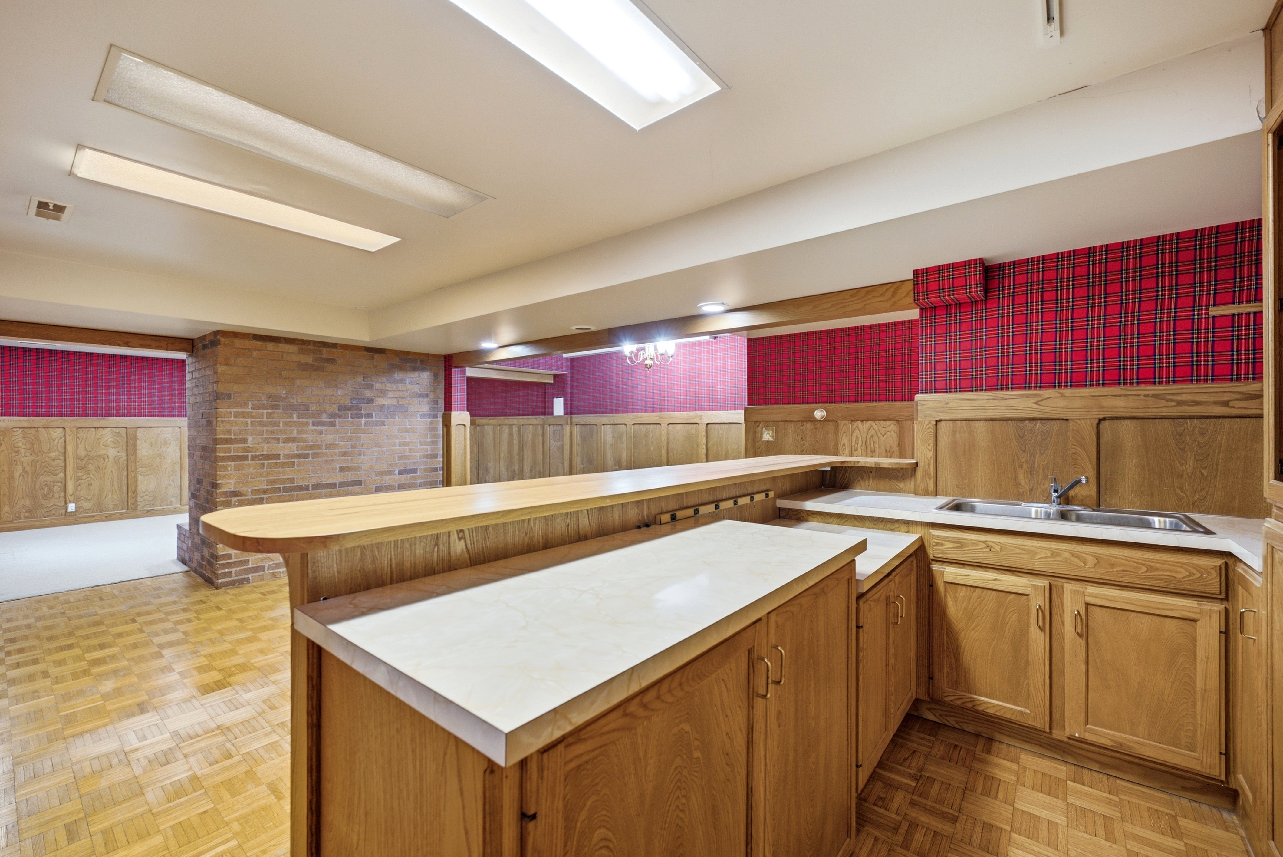 Built-in wet bar featuring a stainless steel sink, wood cabinetry, and light-toned countertops