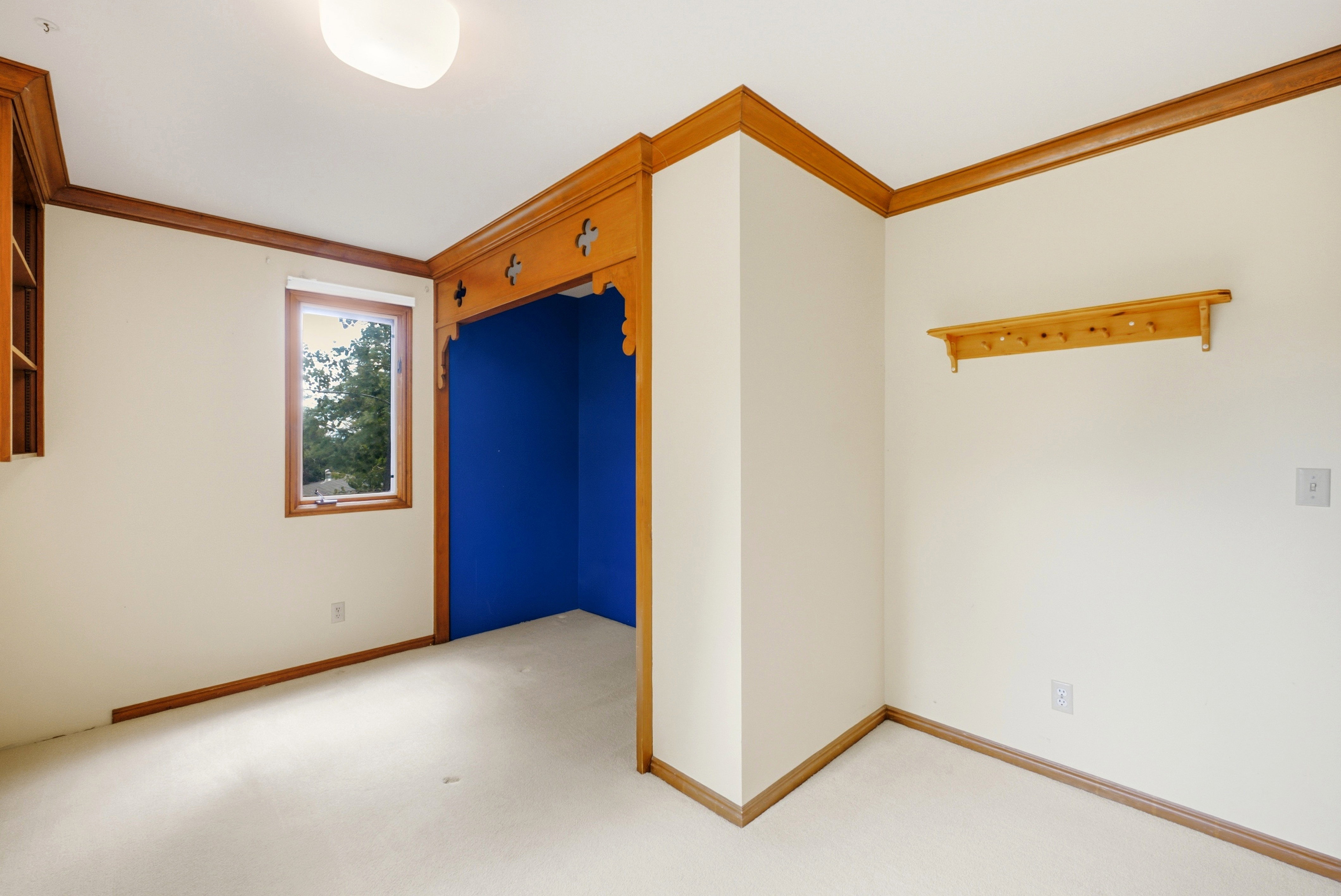 Windowed room featuring white walls and light-toned carpeting