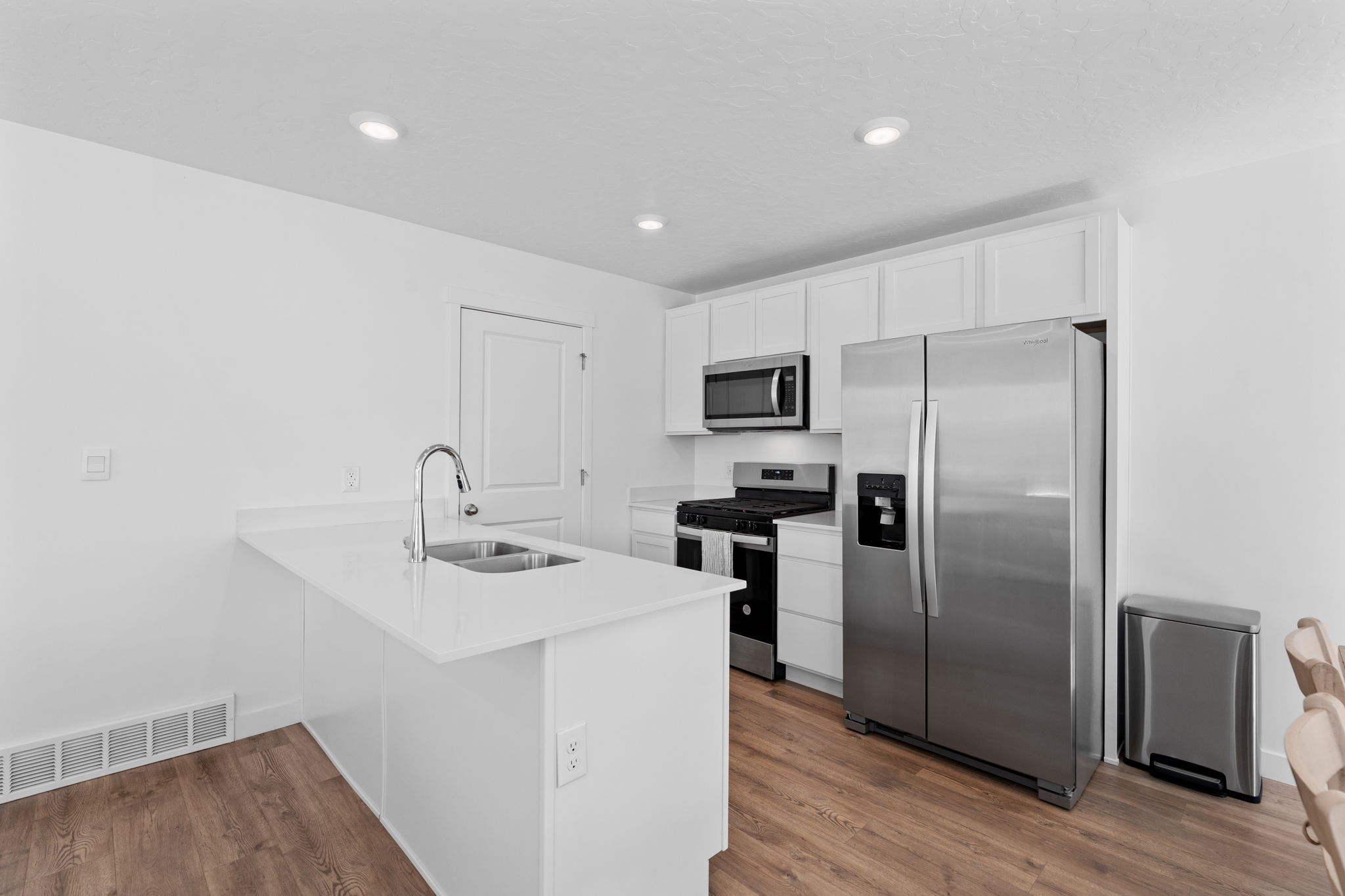 Kitchen. Stainless Steel Appliances. White Cabinets. Quartz tops. Gorgeous warm solid surface flooring. Large windows! Can lights. Beautiful white walls. Bright! Open Concept!