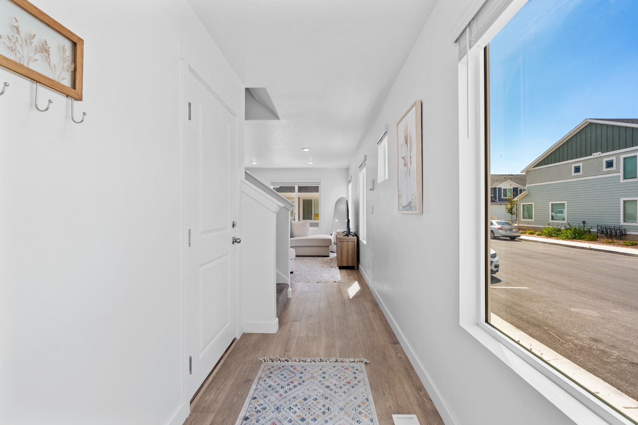 Entryway. Gorgeous warm solid surface flooring. Large windows! Beautiful white walls. Bright!