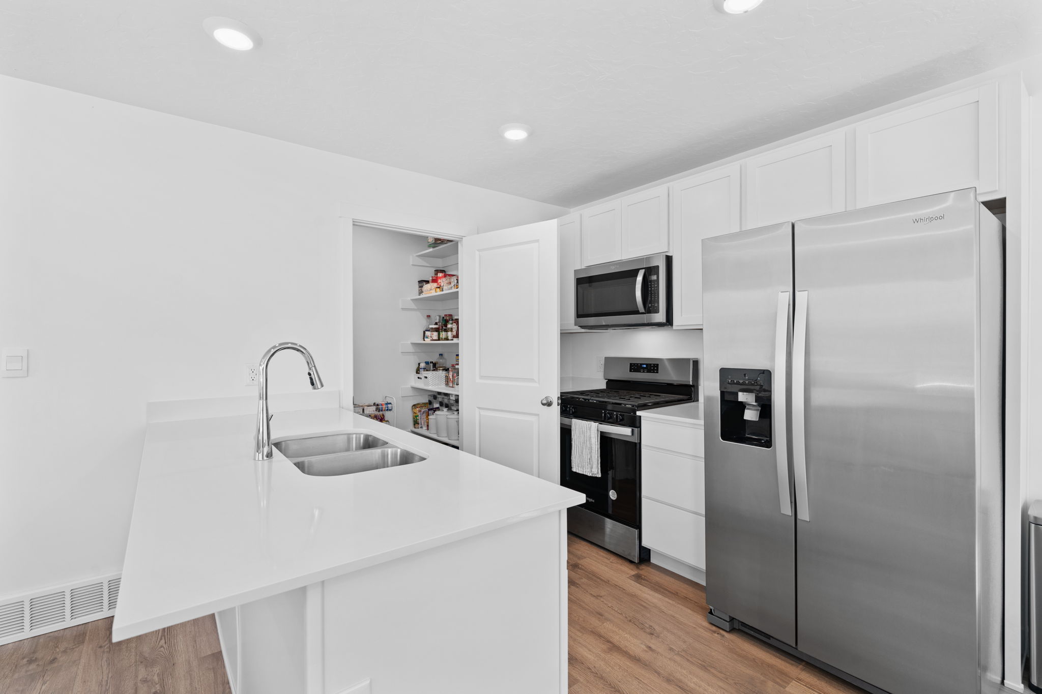 Kitchen. Stainless Steel Appliances. White Cabinets. Quartz tops. Gorgeous warm solid surface flooring. Large windows! Can lights. Beautiful white walls. Bright! Open Concept!