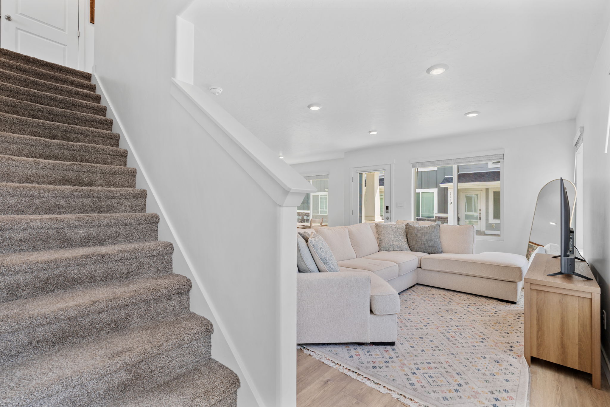 Entryway. Stairs to 2nd level. Gorgeous warm solid surface flooring. Large windows! Can lights. Beautiful white walls. Bright! Open Concept!