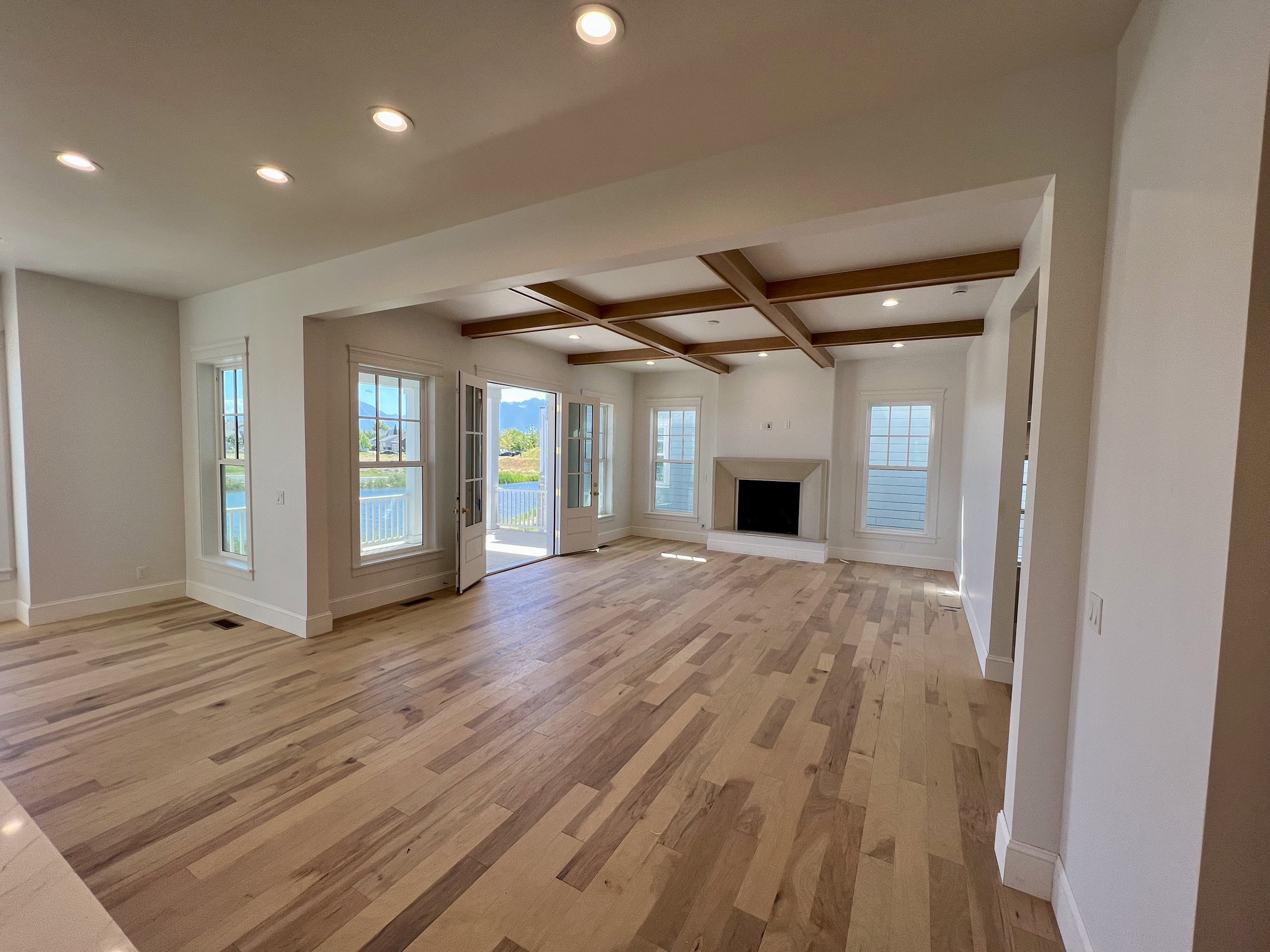 Spacious room with wood-finish flooring, recessed lighting, and a coffered ceiling