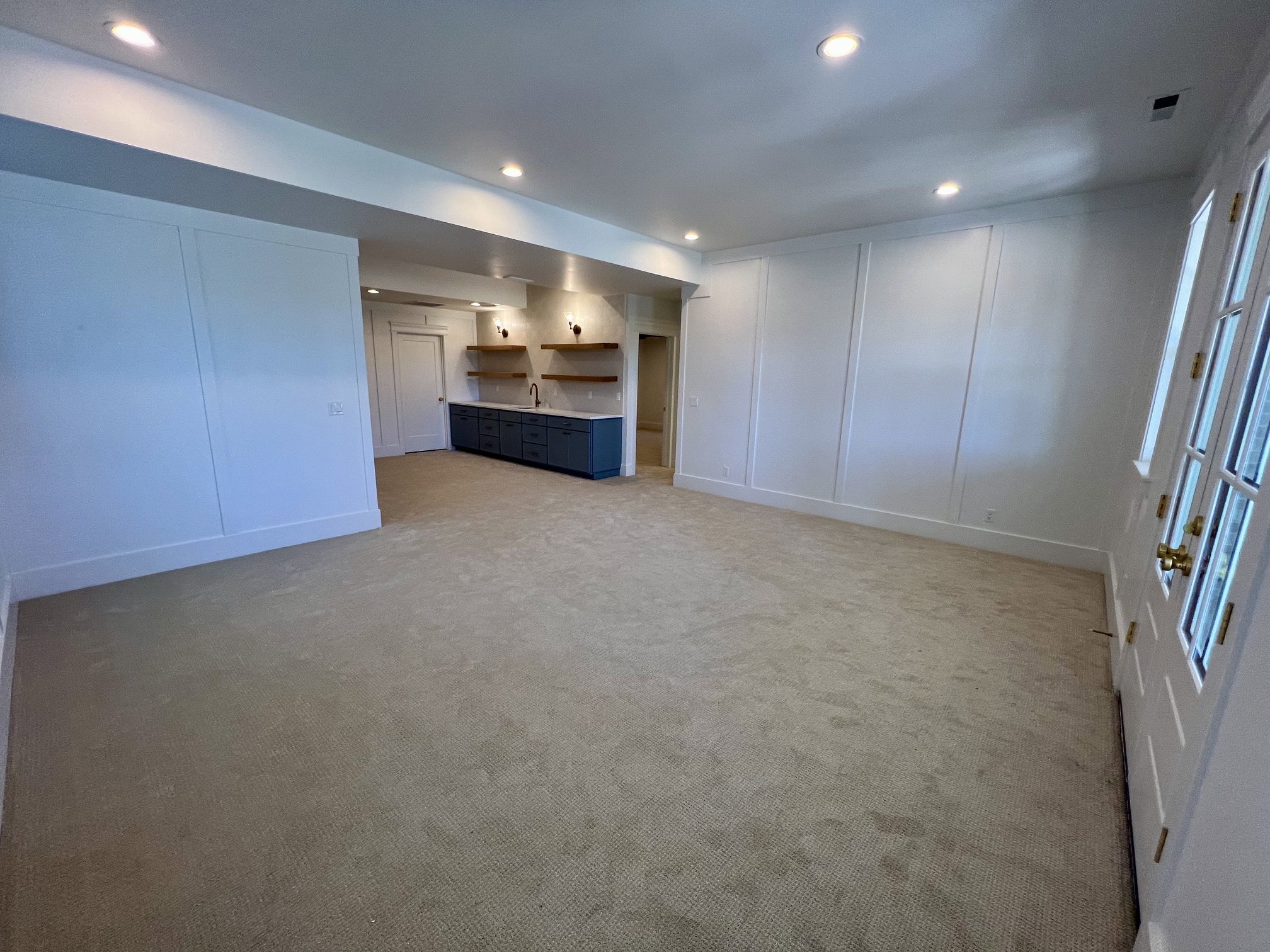 Spacious carpeted room featuring recessed lighting and wainscoting