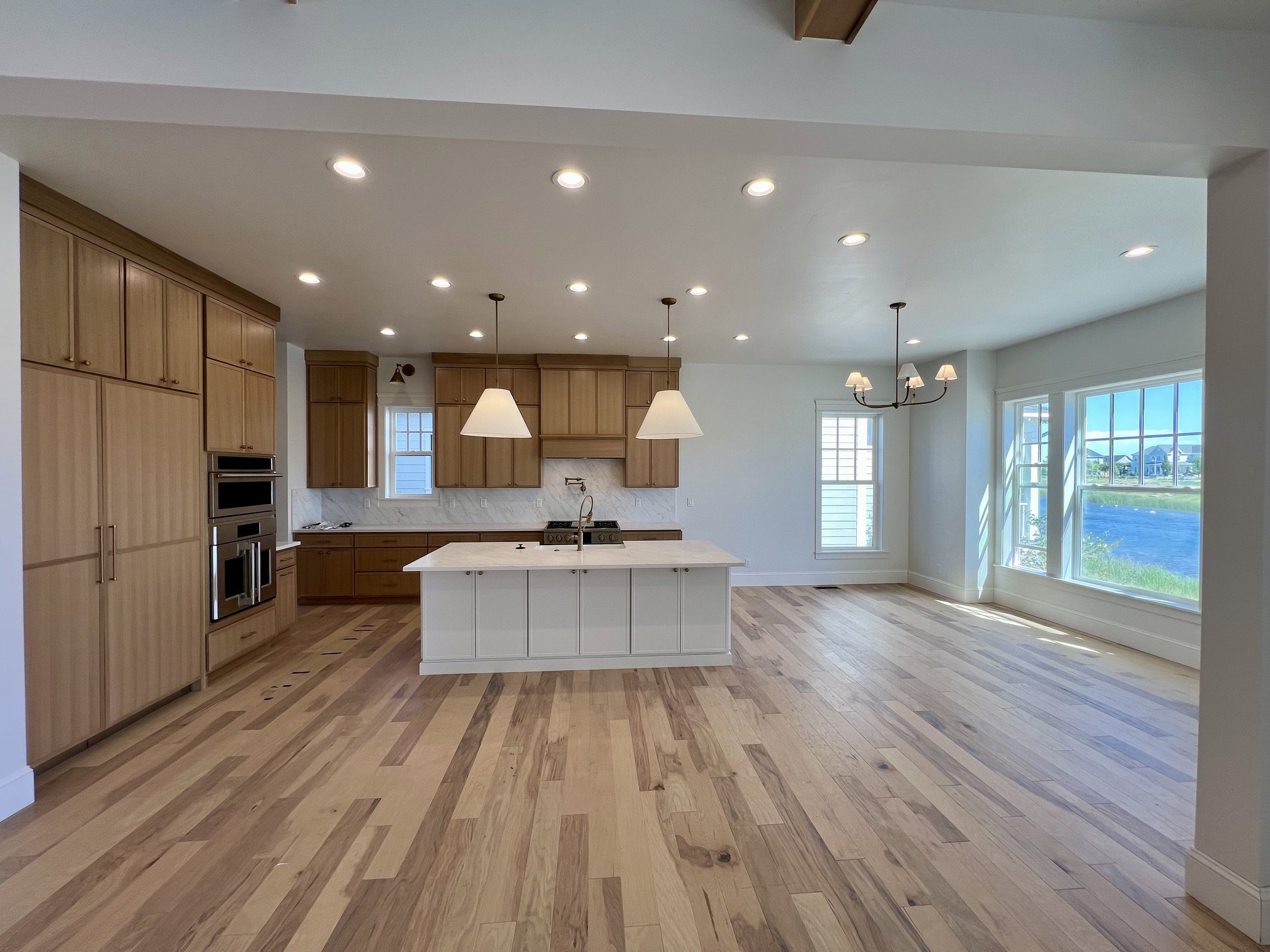 Expansive open-concept kitchen and living area featuring wide-plank wood-finish flooring