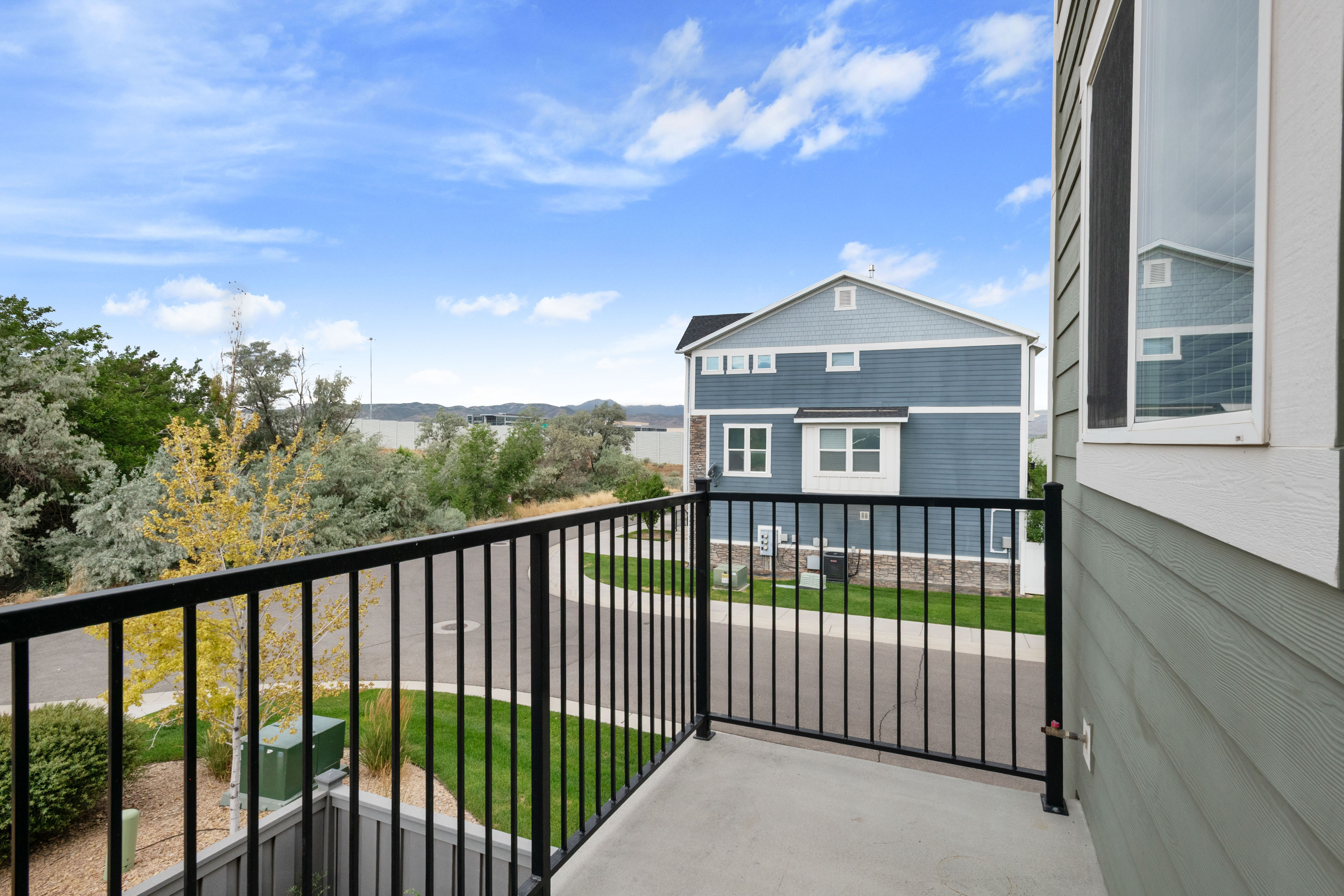 Outdoor balcony featuring a black metal railing and concrete flooring