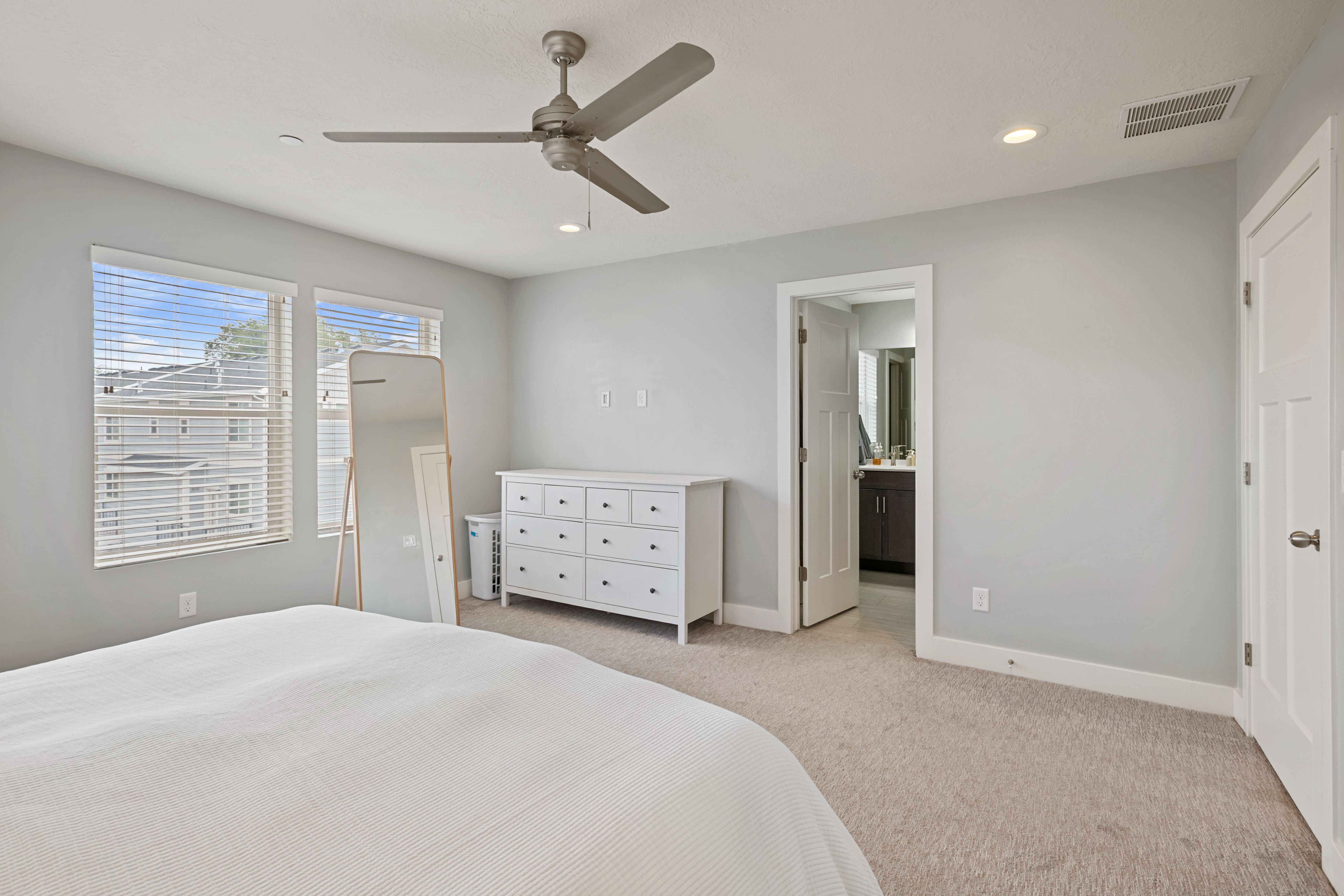 Carpeted bedroom with a ceiling fan and recessed lighting