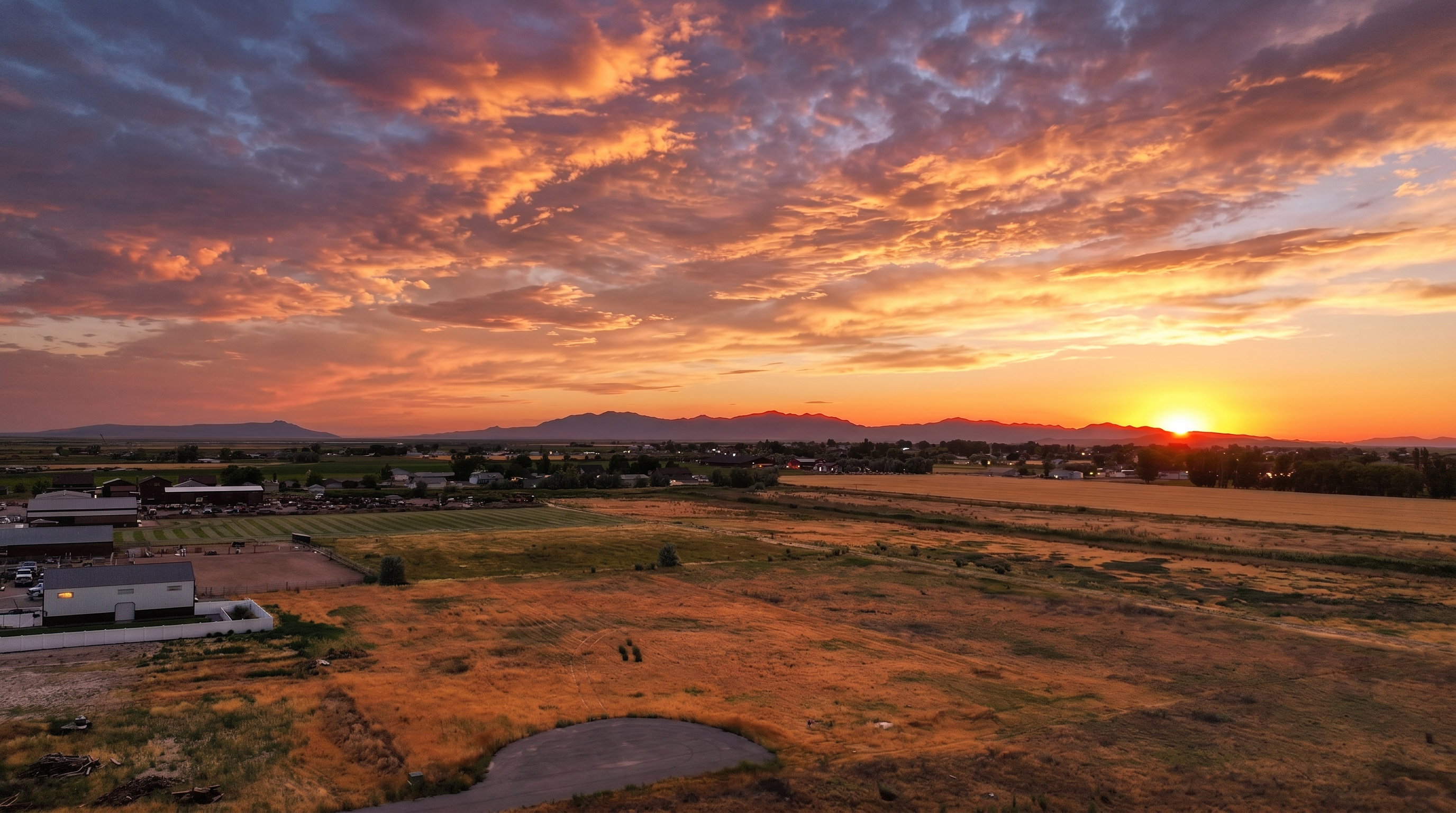 Expansive rural landscape featuring a prominent mountain range in the distance