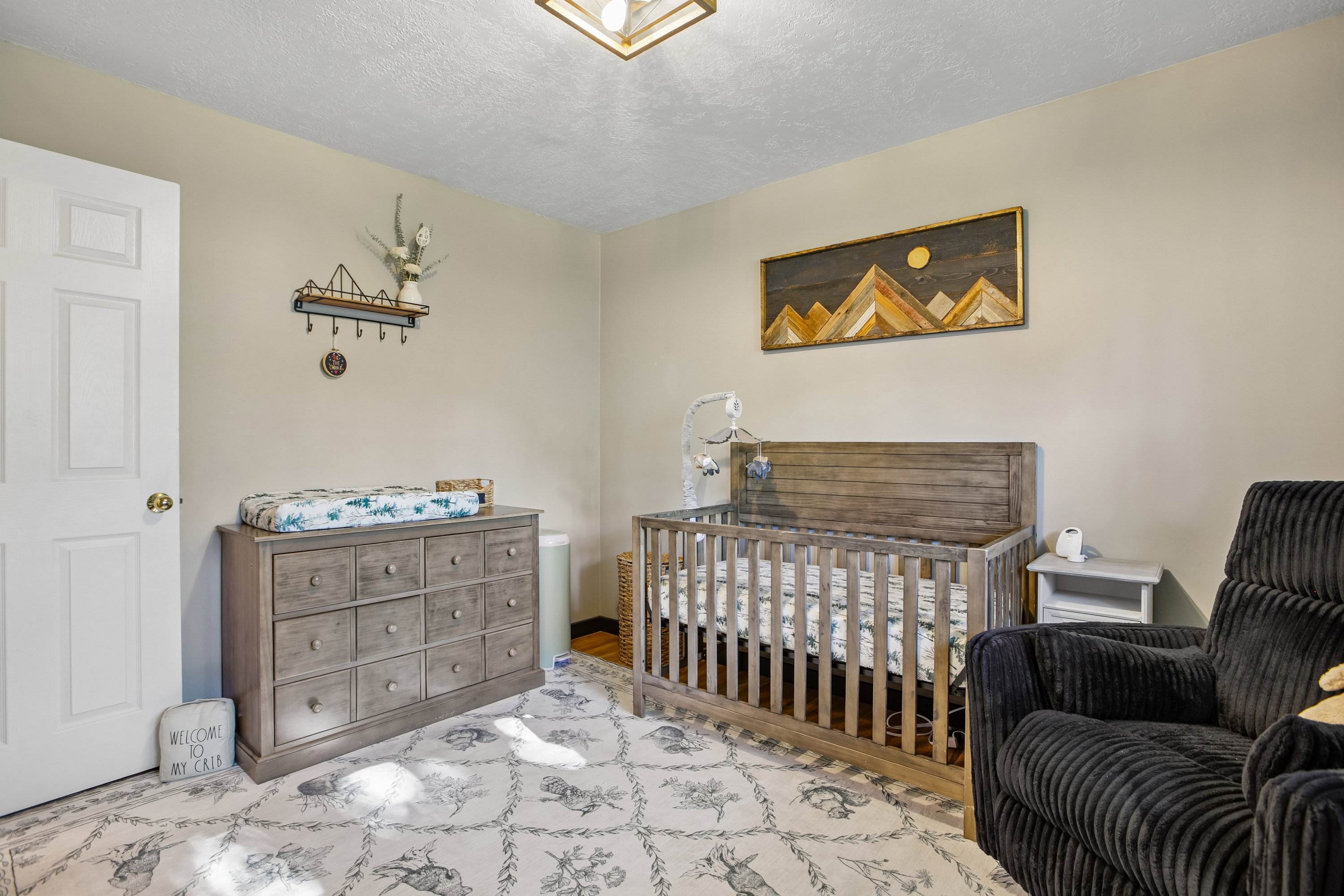 Neutral-toned walls complement the patterned area rug